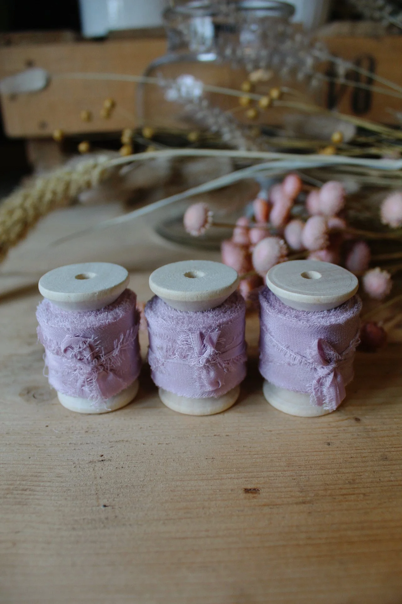 Raw edge silk ribbon on wooden reels in Putty, Nude Blush, Buttermilk, Lilac and Natural.