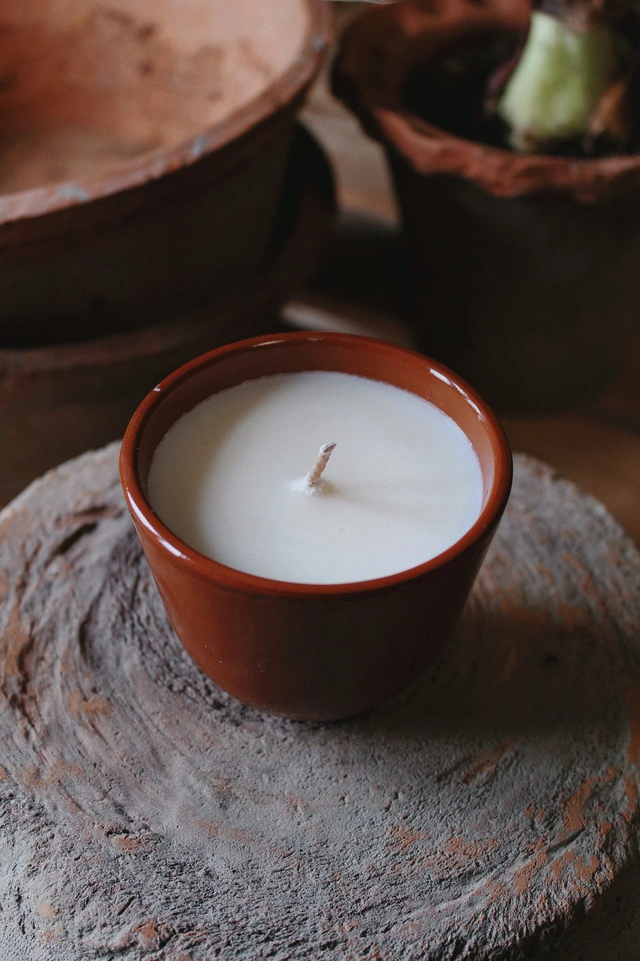 Glazed terracotta Herb Bed candle with a fresh green herbal blend, photographed in the potager studio.