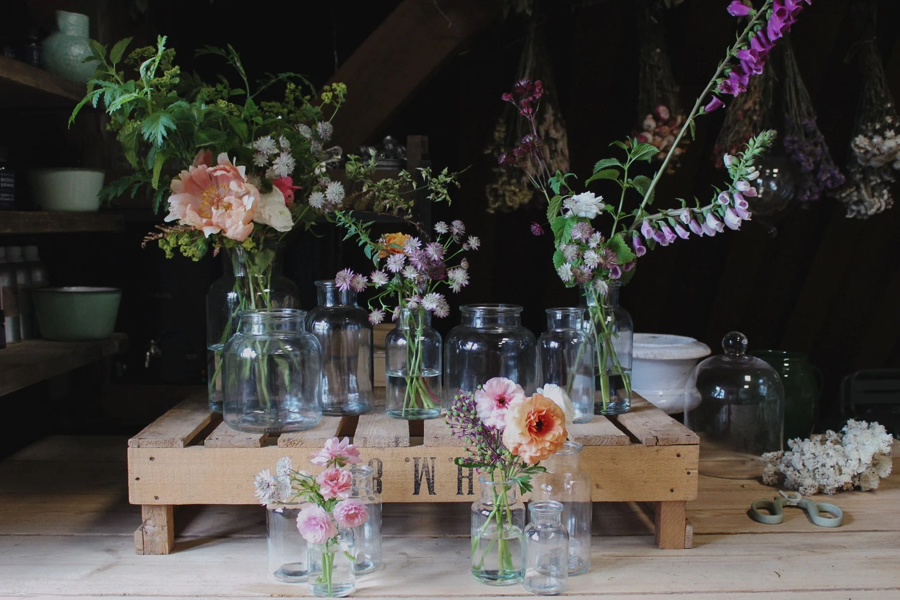 Botanical Heritage wedding vase collection with glass vessels filled with seasonal flowers and natural foliage.