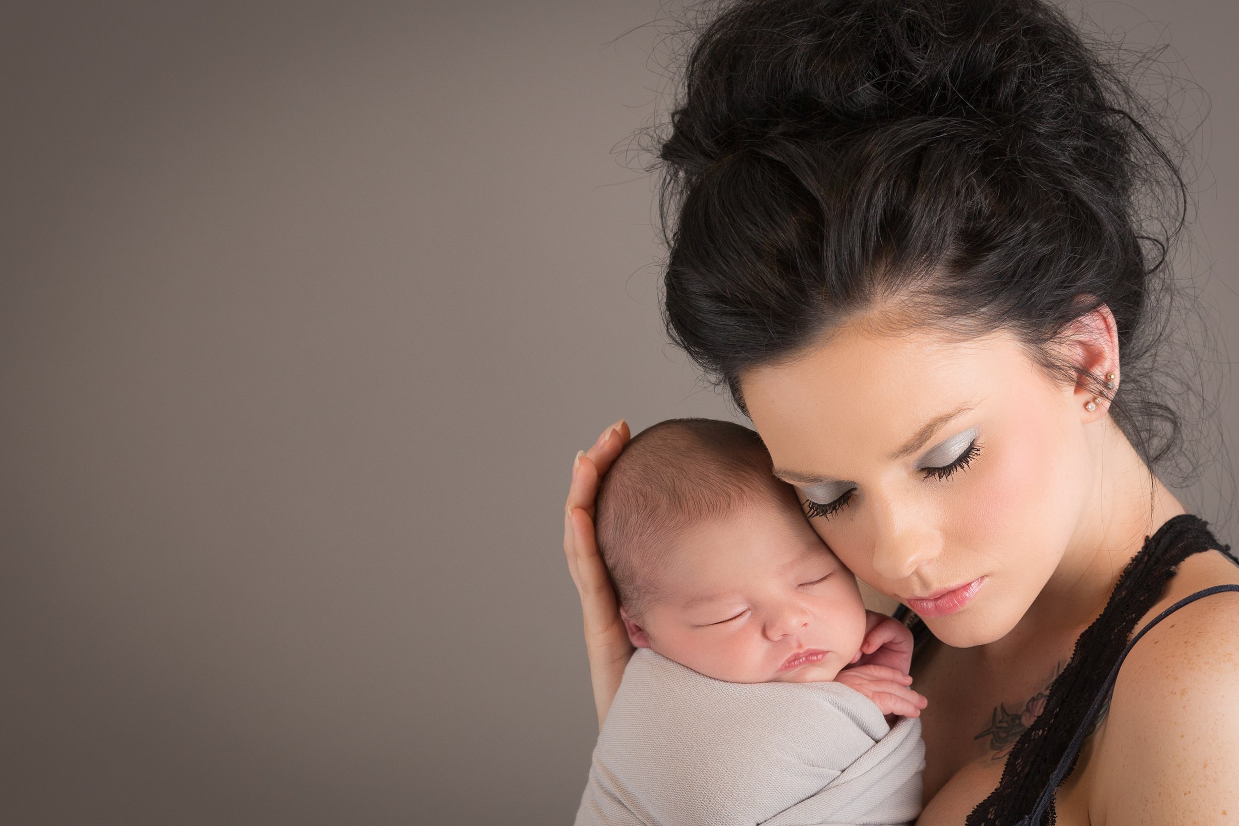 portrait of mother holding newborn baby 