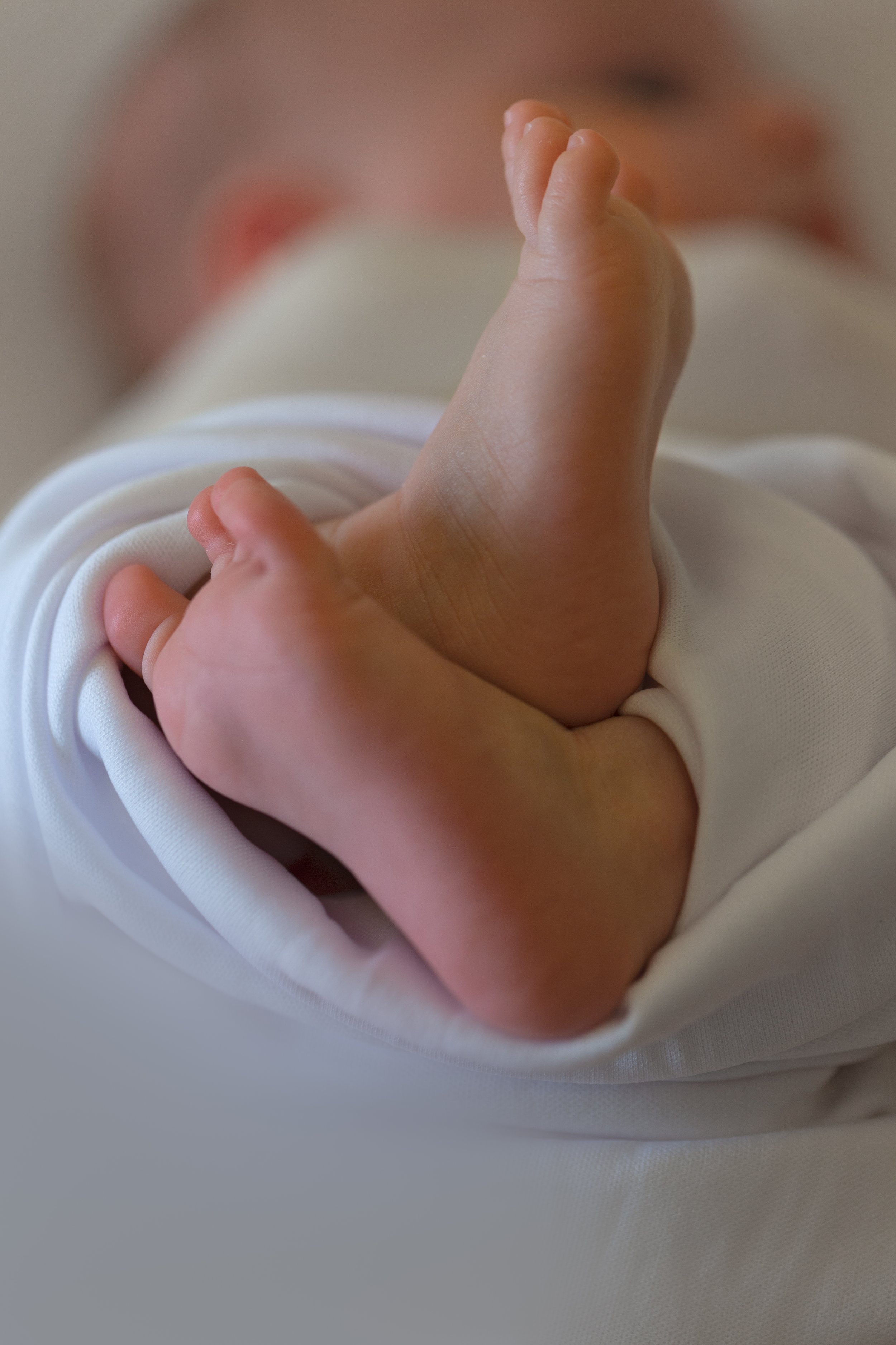 close up photo of newborn feet in swaddle
