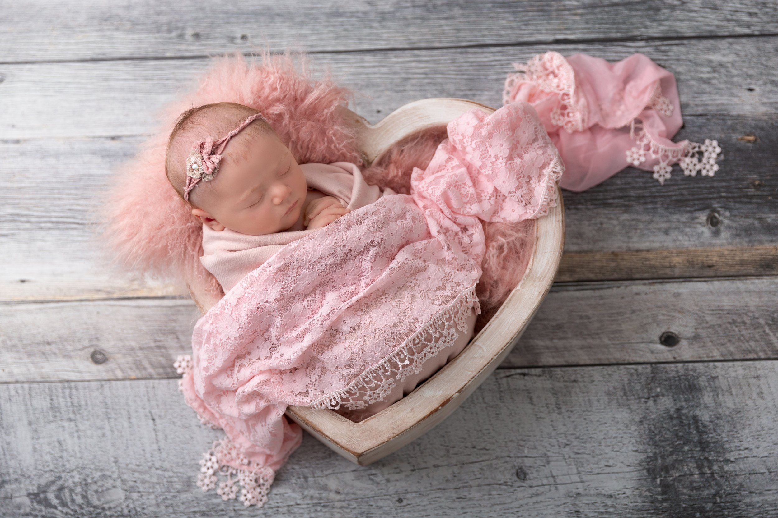 baby girl in wood heart bowl