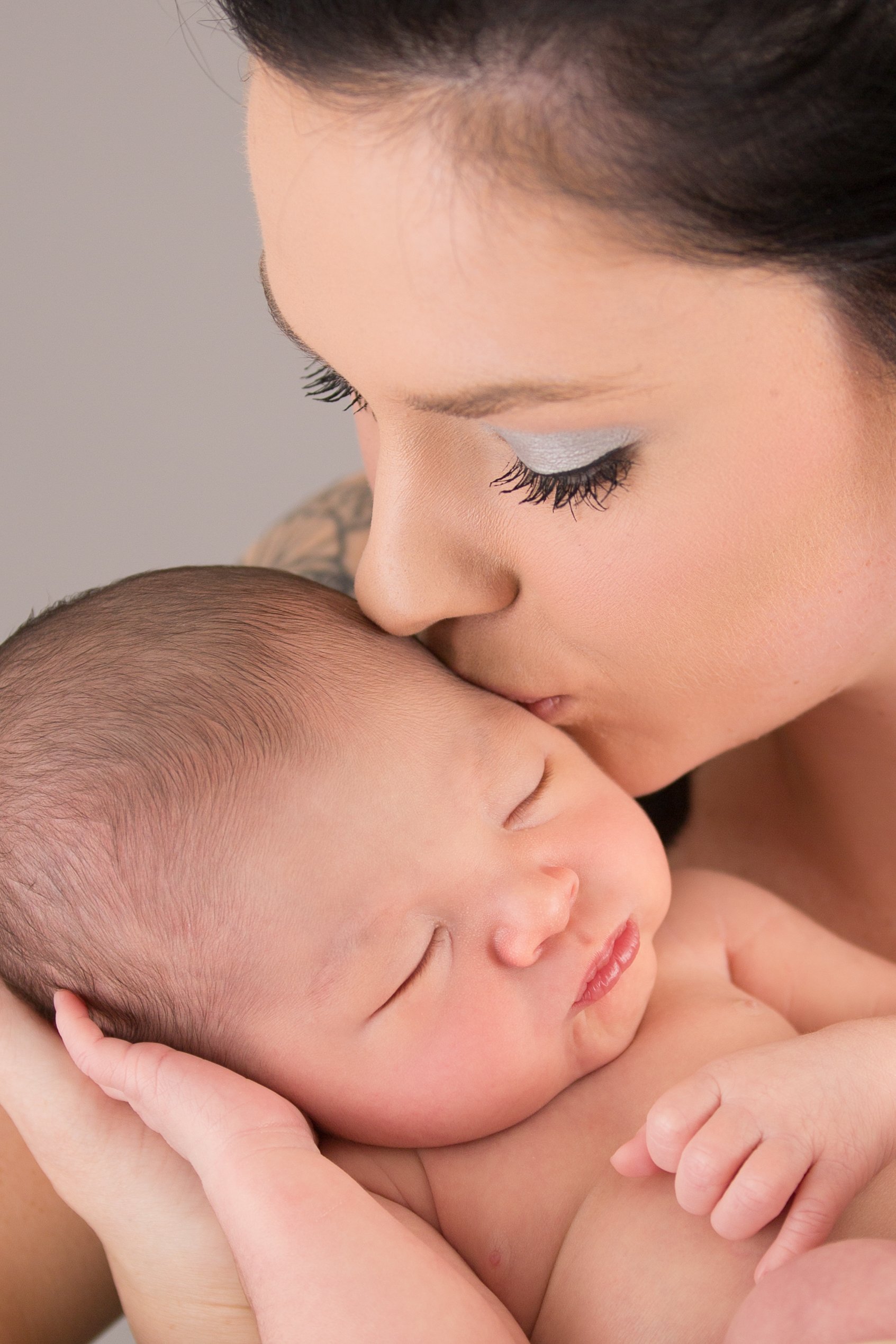 mom kissing newborn baby boy