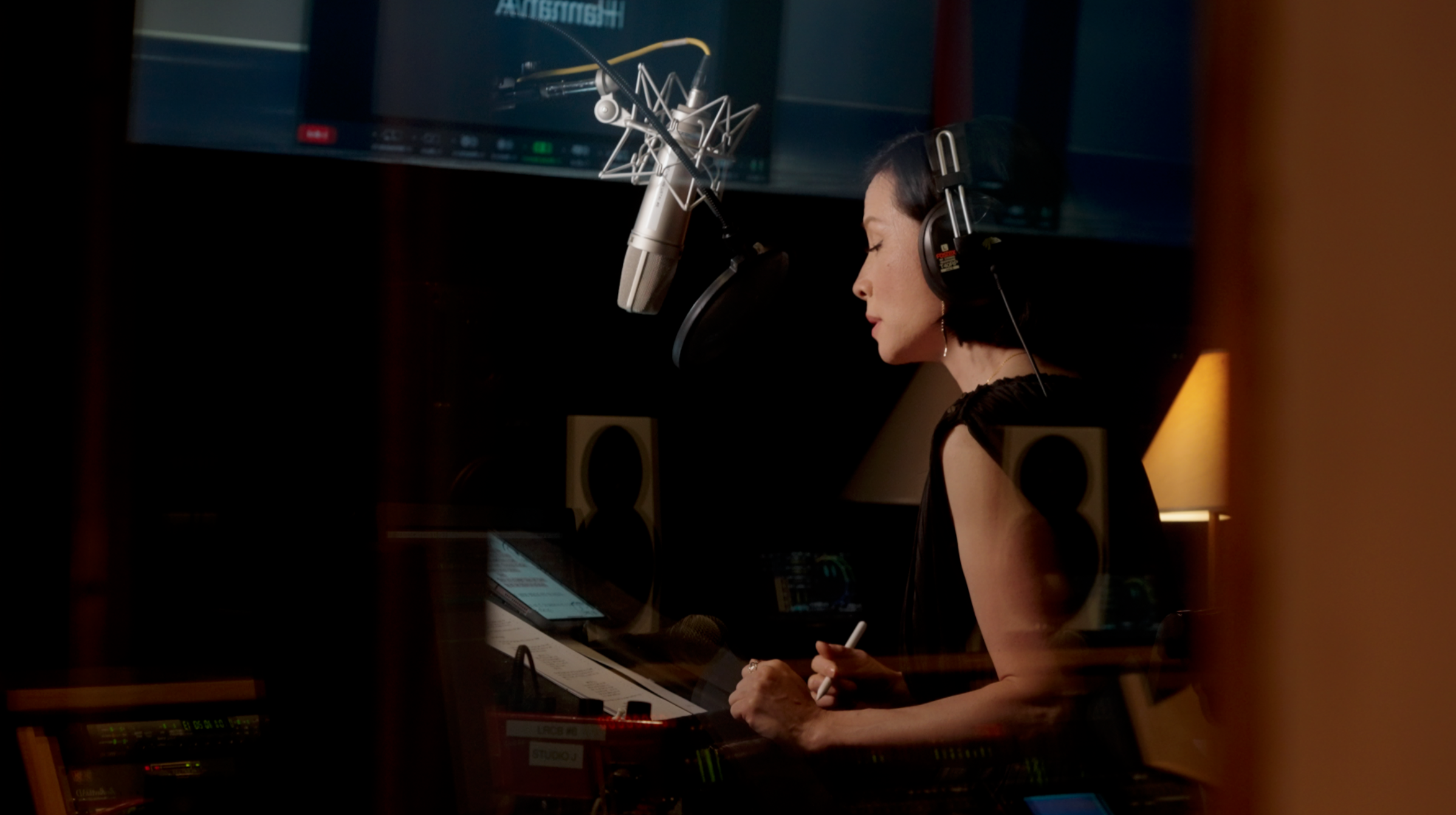 Lucy Liu recording vocals for The Pirate Queen VR game in studio, headphones on, directed by Eloise Singer
