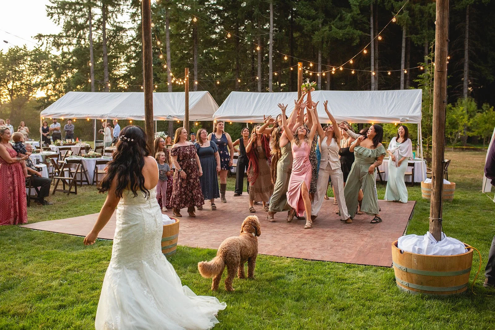 Outdoor wedding reception at Riverbend Orchard with guests dancing under string lights in a forest setting near Portland, Oregon