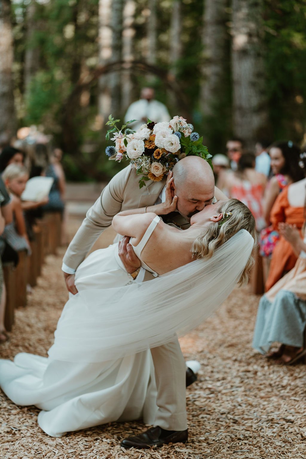 Bride and groom facing crowd holding sparklers at night wedding celebration