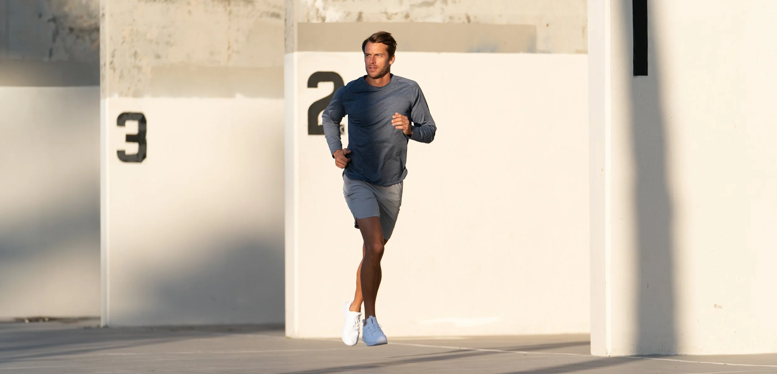 Male model running in navy athletic apparel during an outdoor product photography shoot
