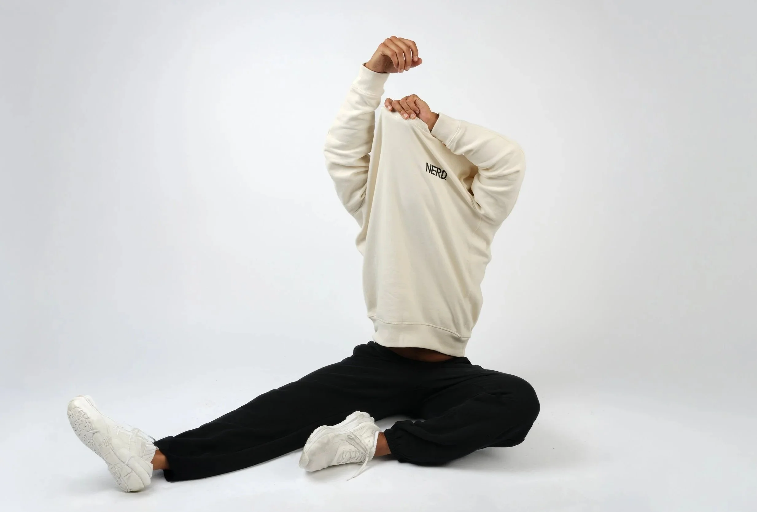 Men cream hoodie model seated floor pose — activewear product photographer Los Angeles