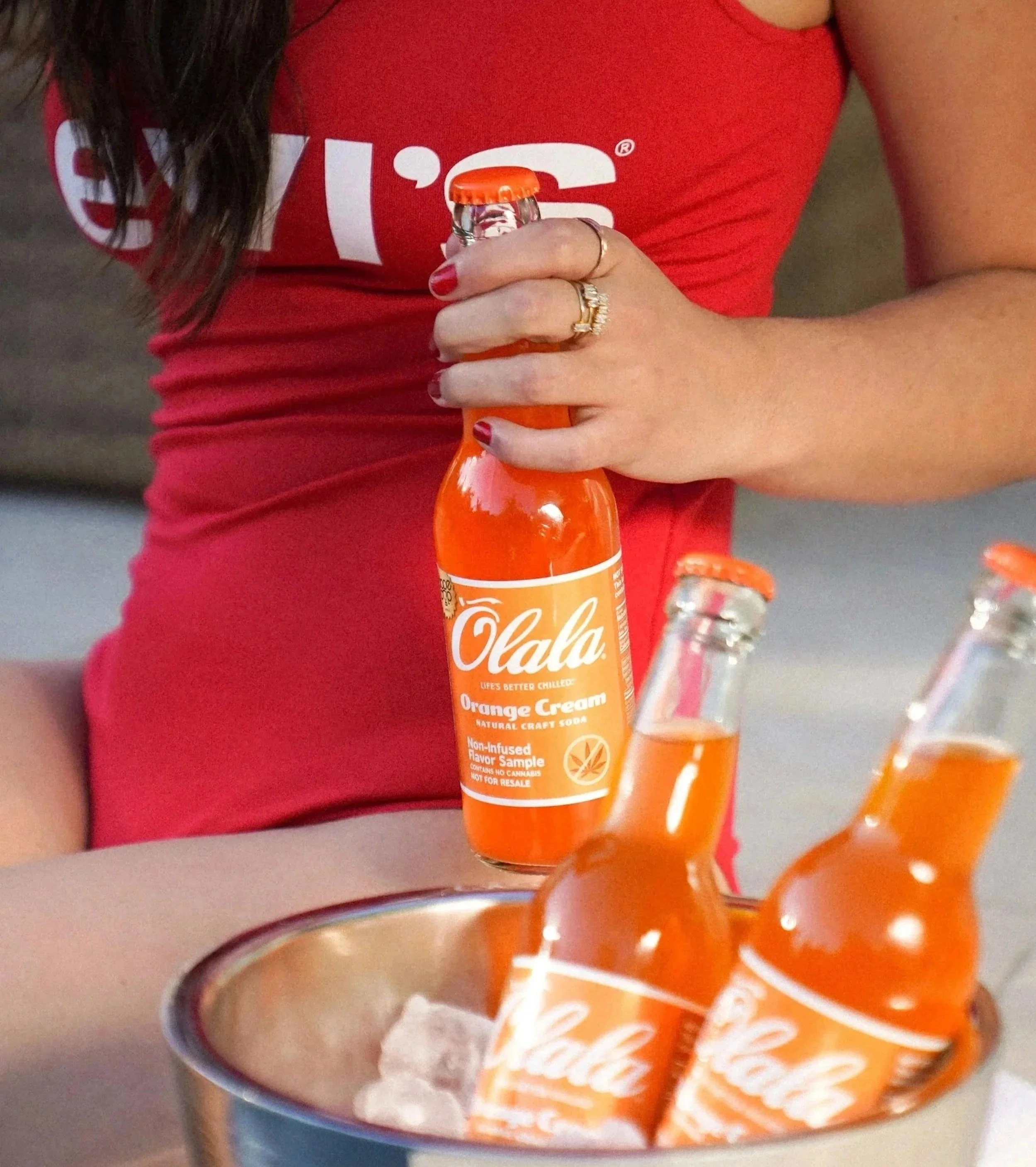 Woman in red Levi's tank holding Olala orange cream soda — beverage lifestyle product photographer Los Angeles