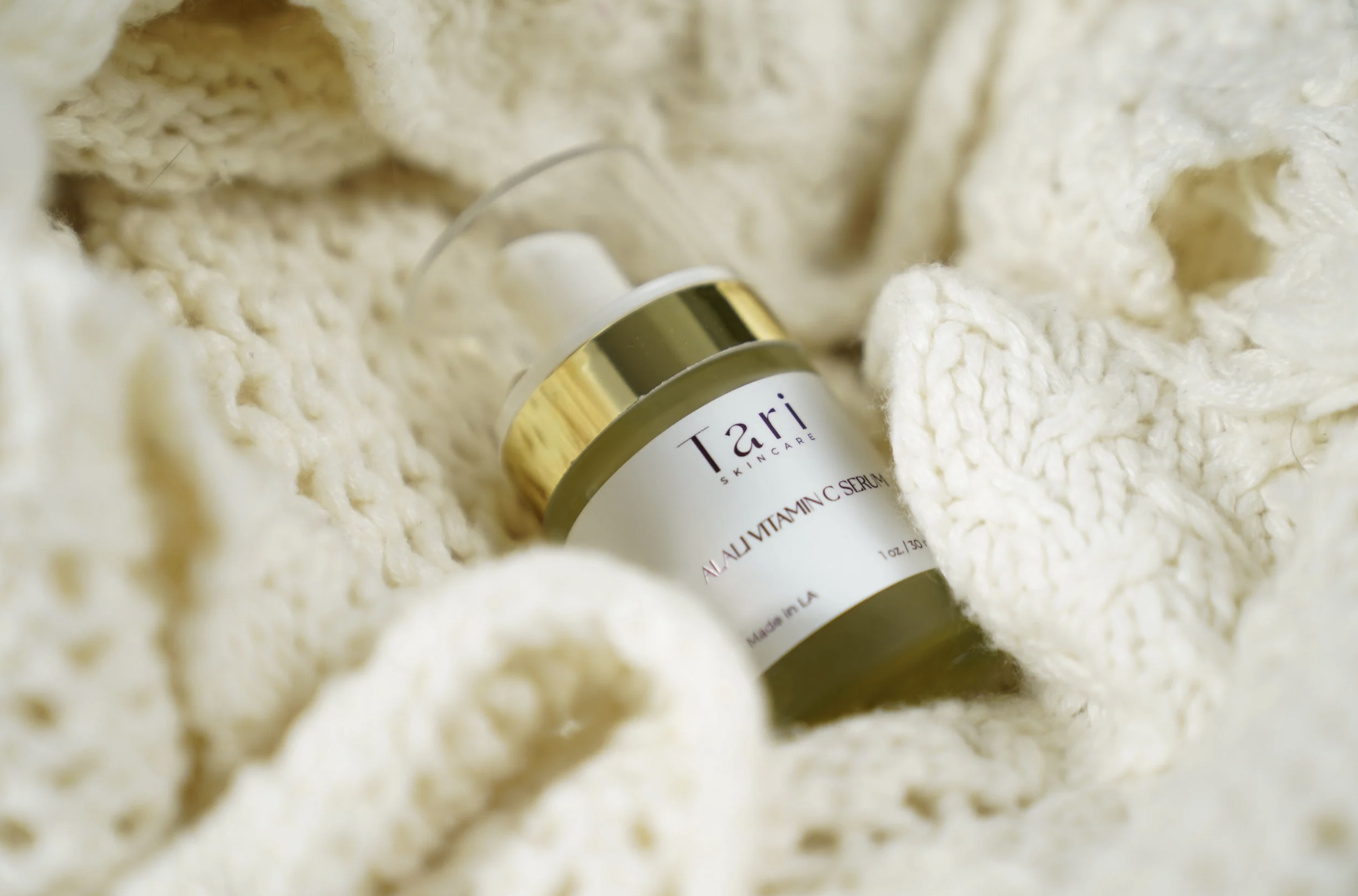 Tari Premium Skincare vitamin C serum bottle styled in soft cream knitted fabric