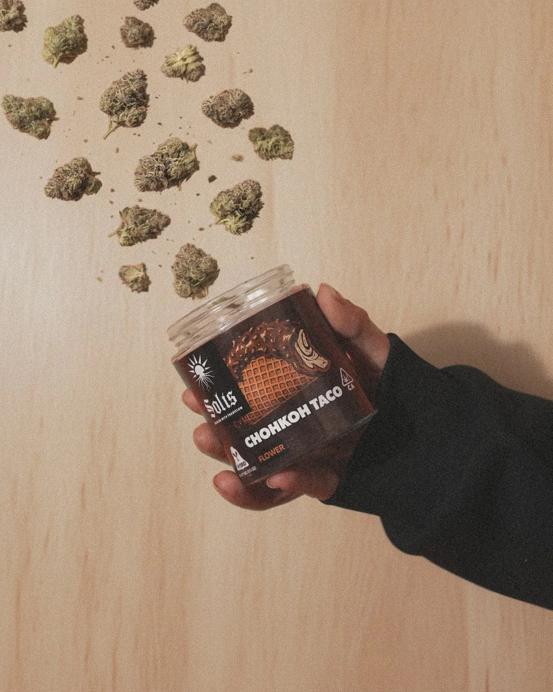 California cannabis brand photography of Solis flower jar held by hand with loose buds