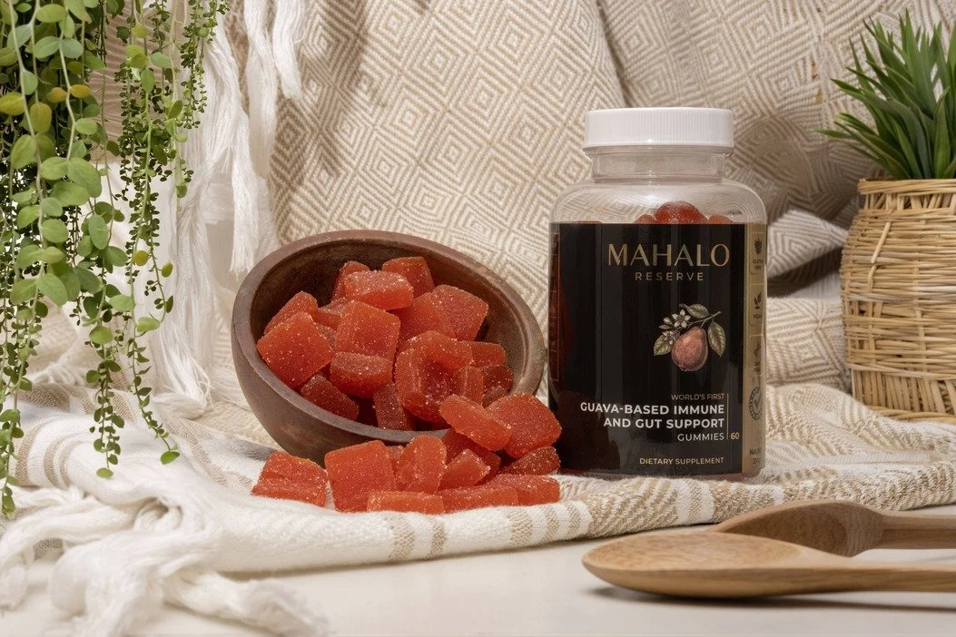 Mahalo Reserve guava gummies and packaging photographed in warm controlled light with natural textiles and earthy props for a premium ecommerce lifestyle image