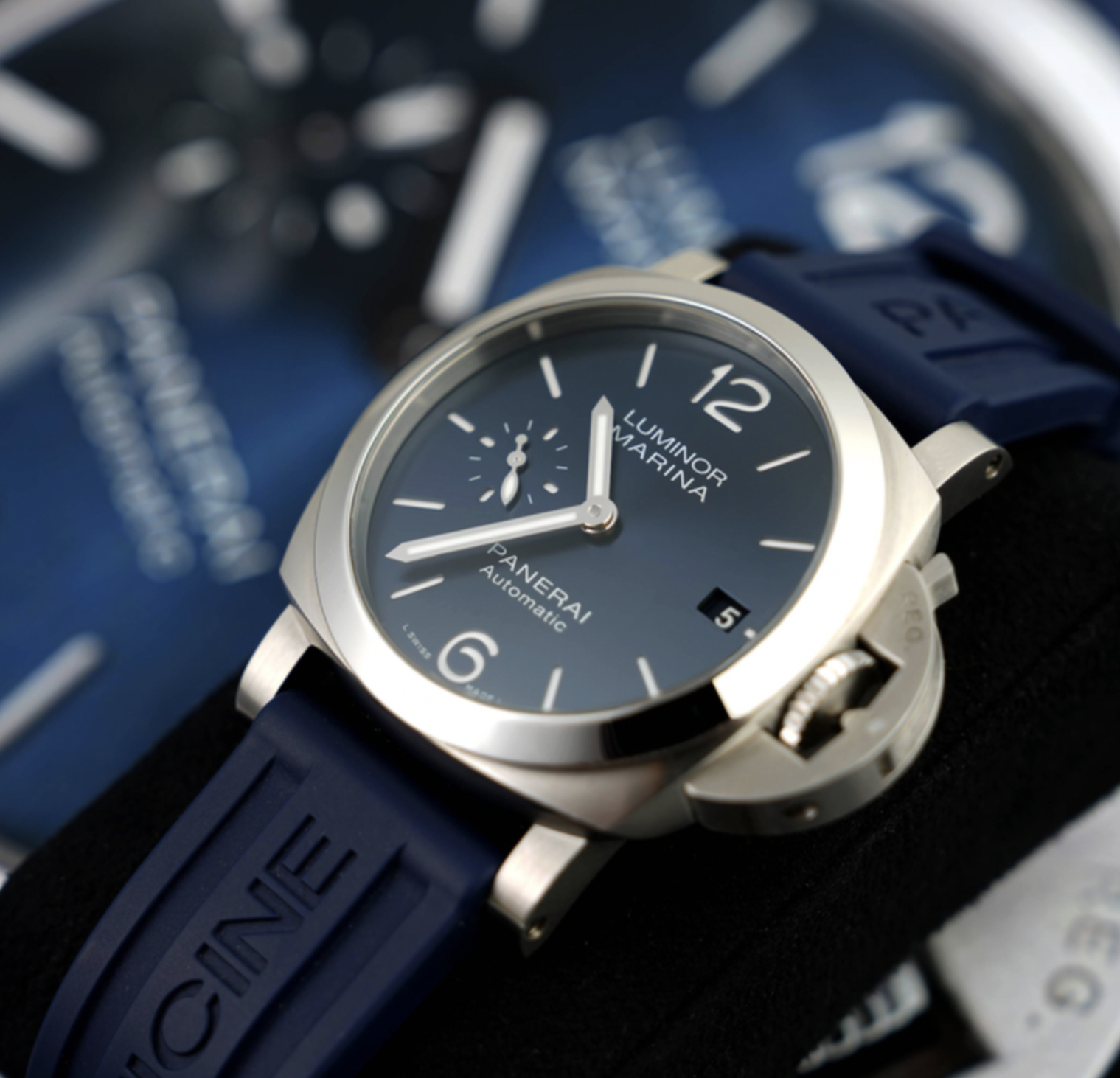 Close-up product photograph of a Panerai watch with a blue dial and matching blue strap