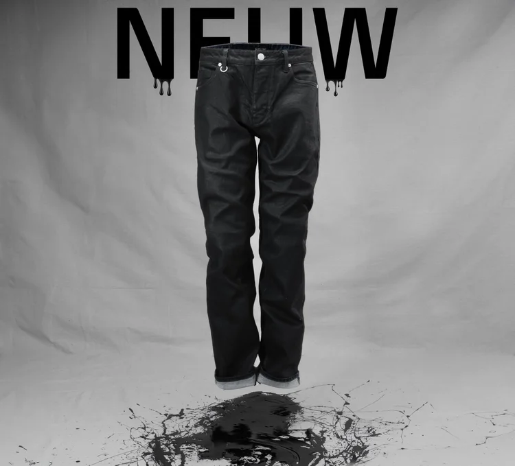 Conceptual commercial fashion photograph of black trousers against a monochrome NEUW graphic, using controlled studio light and subtle tonal separation to retain texture in the black fabric while preserving the minimalist advertising design