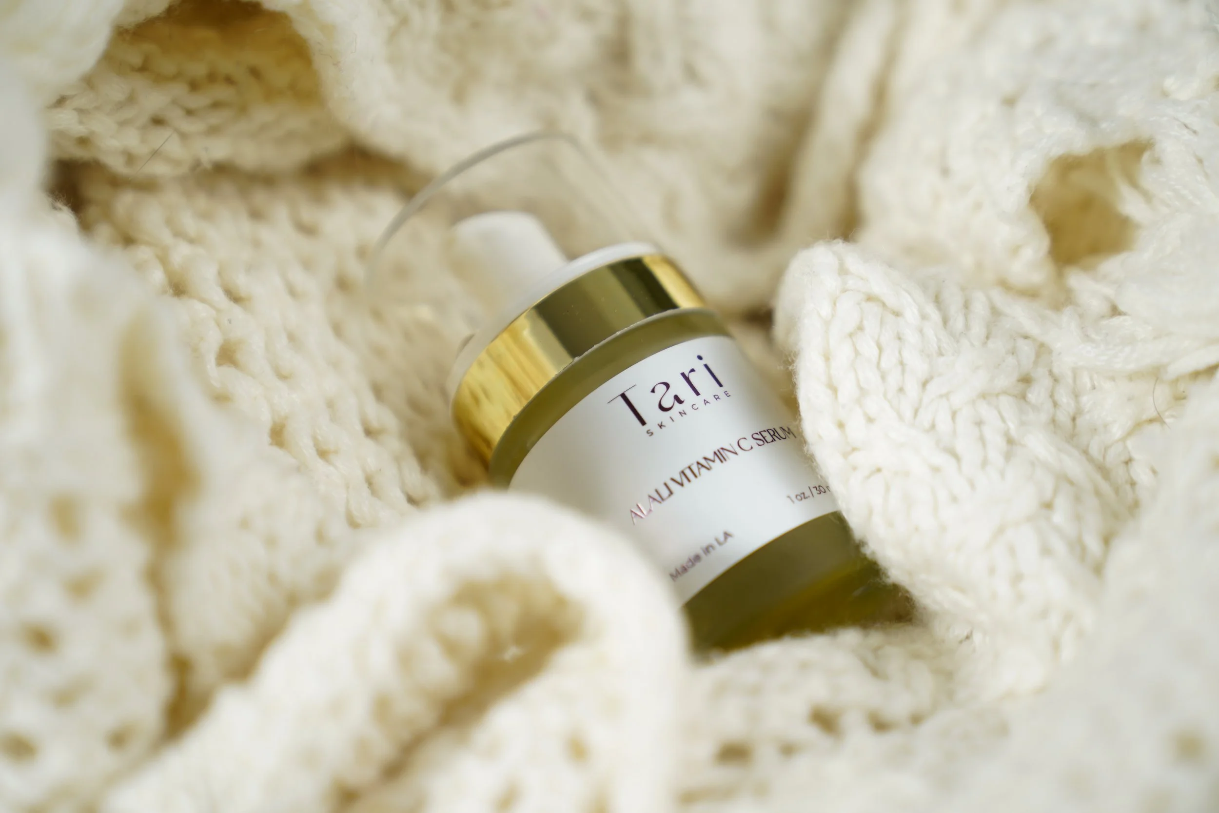 Lifestyle product photo, Tari skincare jar on knit blanket soft editorial lighting