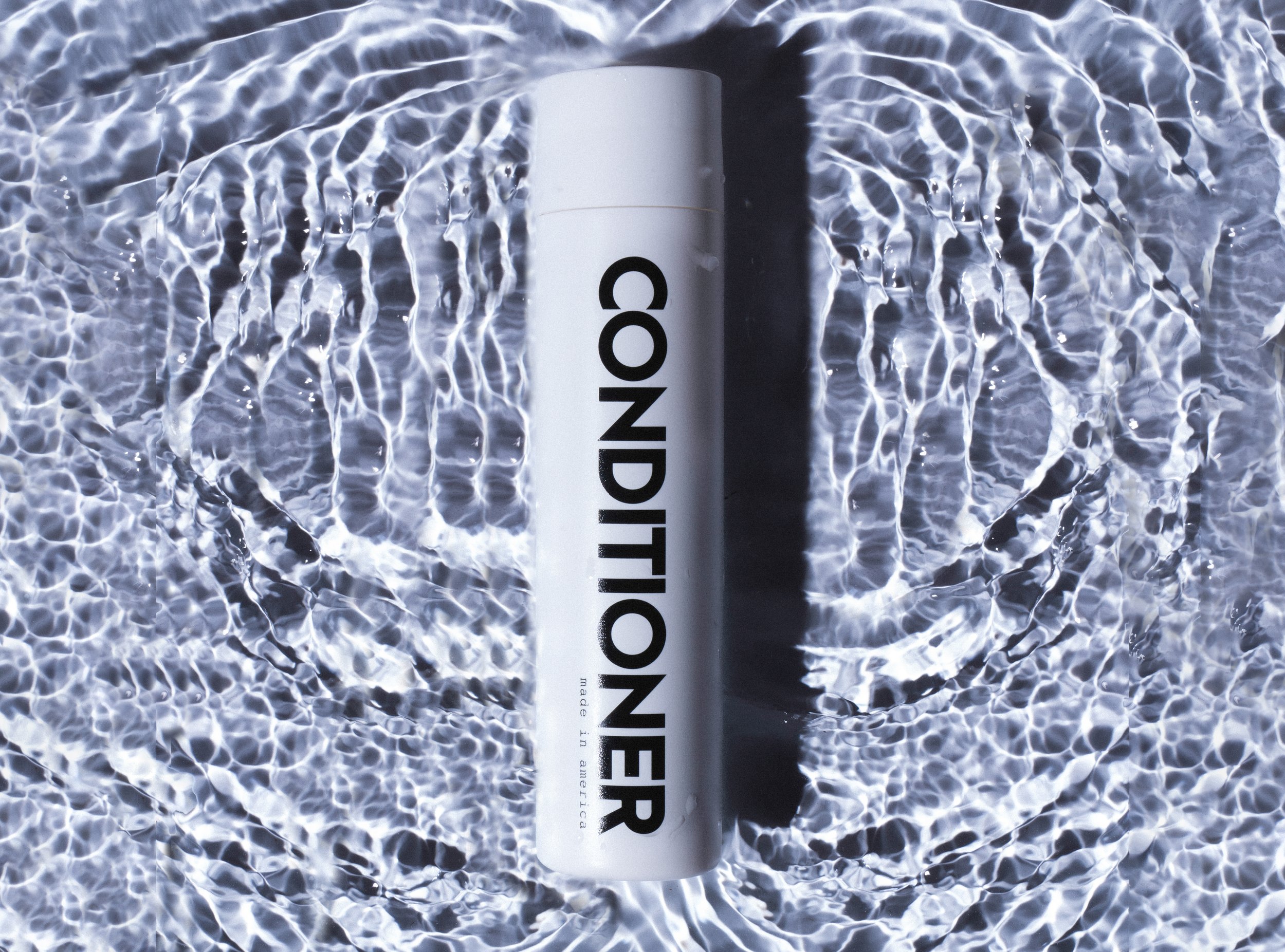 Studio product photography in Los Angeles, conditioner bottle with water splash