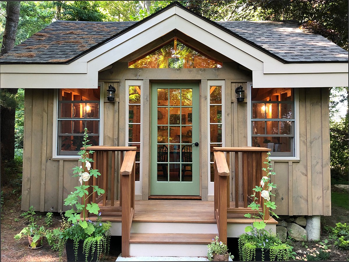 Exterior shot of Amy Thurber's studio, a cozy wooden building surrounded by plants and trees
