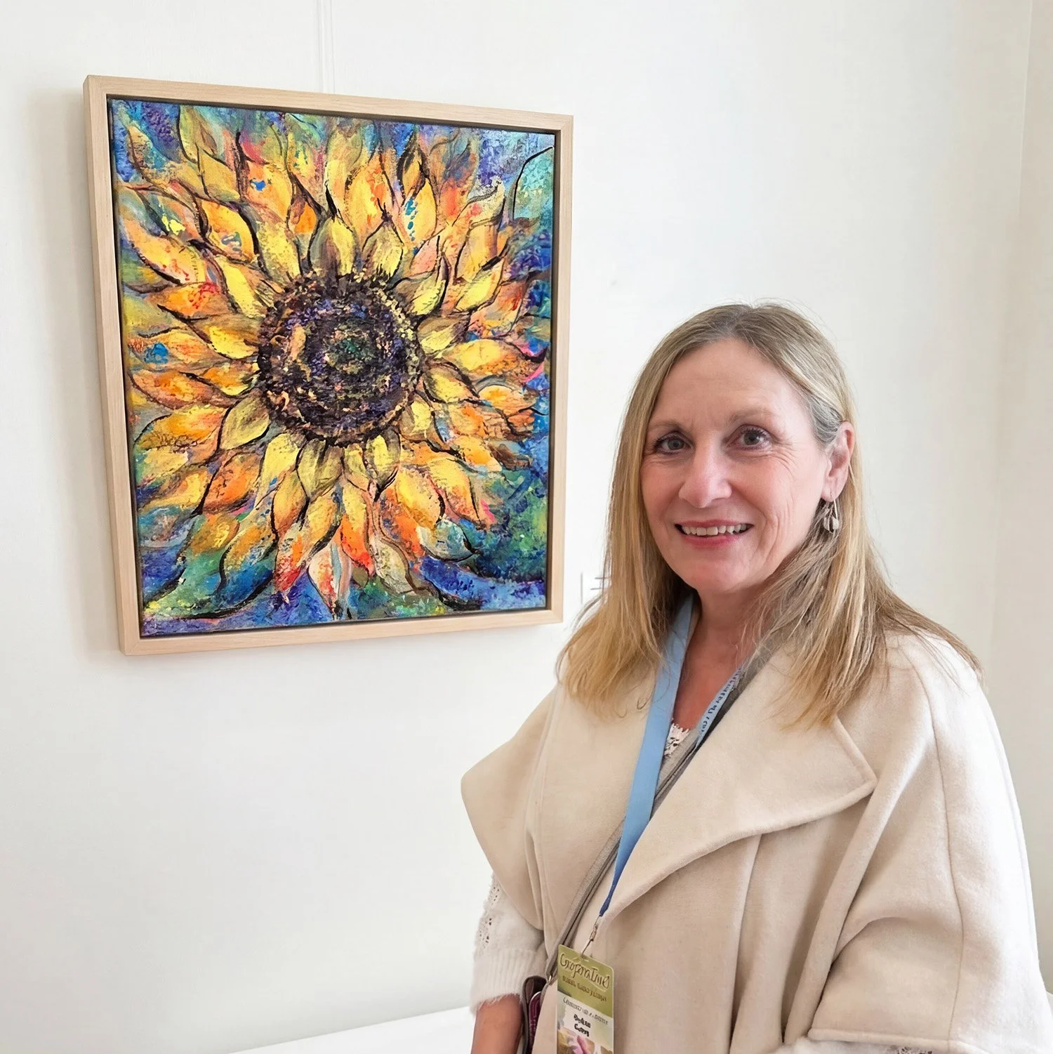 Kristin Putney standing in front of one of her sunflower paintings