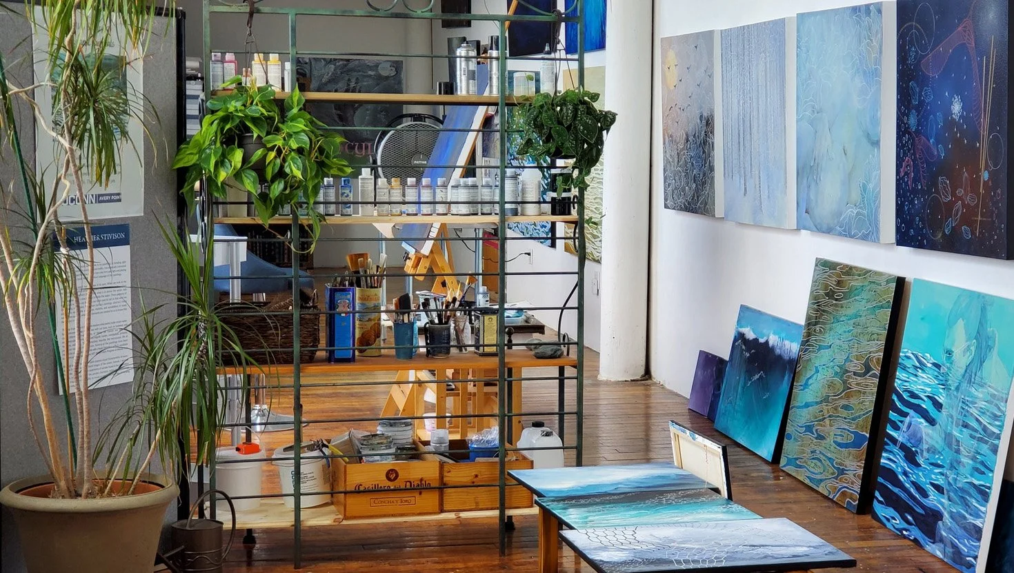 Interior of Heather Stivison's studio, a bright and organized space full of paintings and art supplies