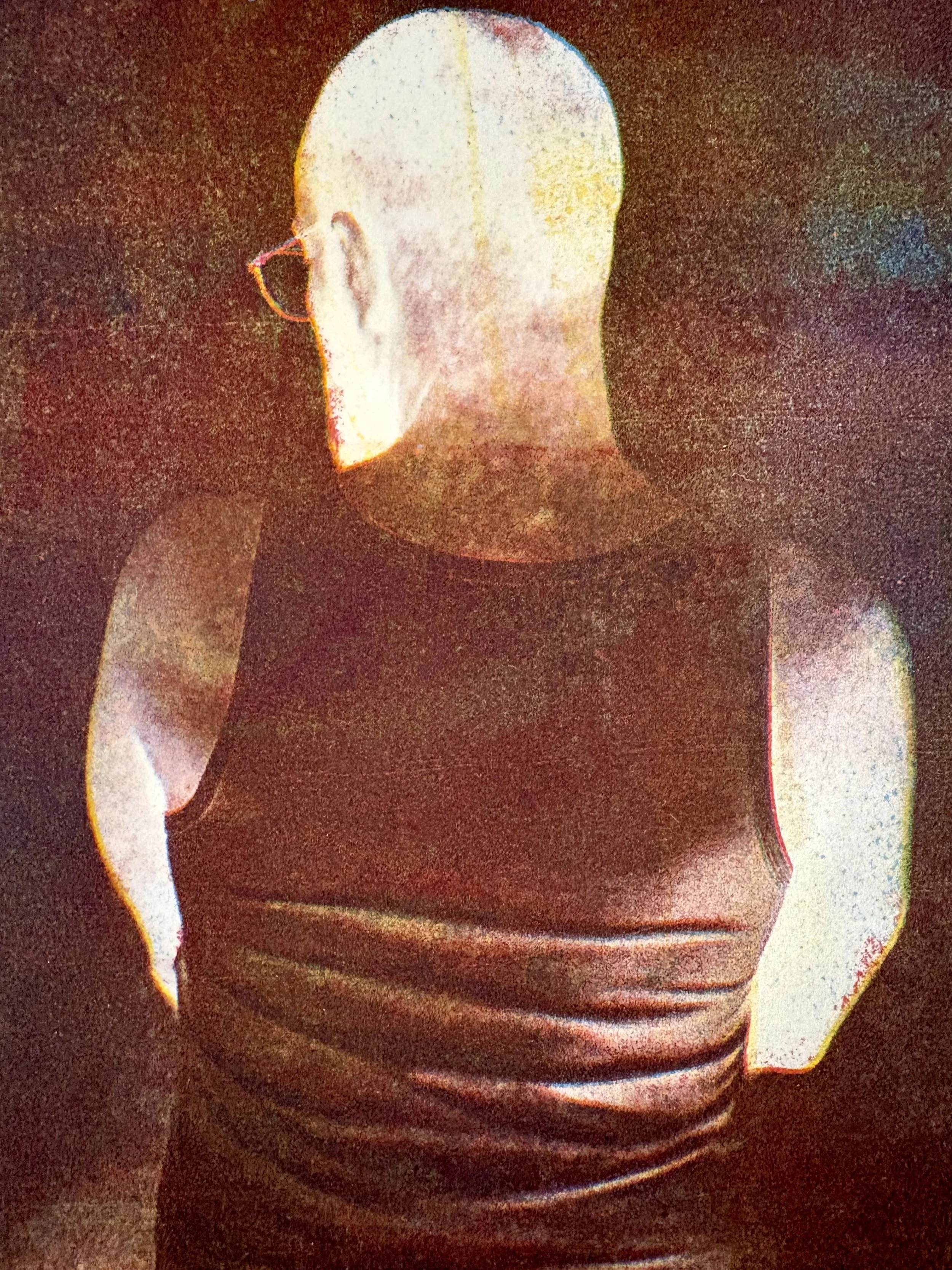  Michael Walden   
 Dark Matter   
10.5" x 8.5"  
Lithographic mono print Dark Matter approaches fire as a felt condition rather than an image. A figure seen from behind emerges through a reversal of light and dark, unsettling the body and placing it