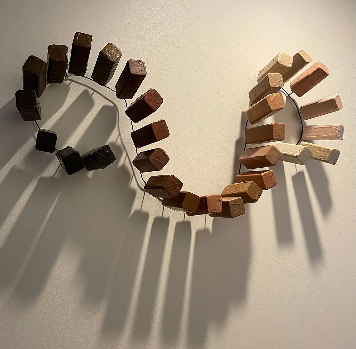 Fallopian Tube, 14” x 29” x 5”, waxed gradients of skin tones on wood and formed metal