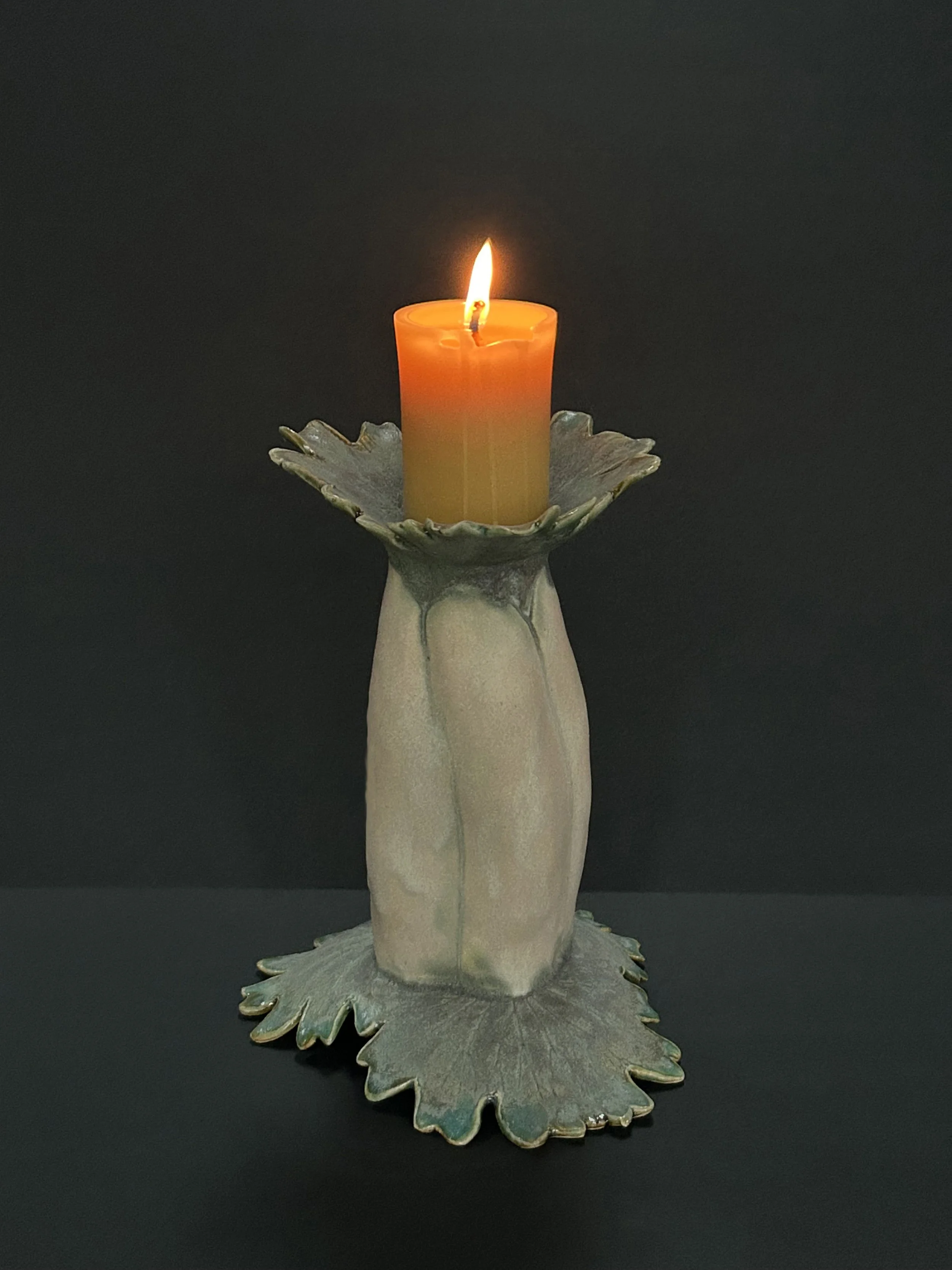  Amy Thurber   
 Ghost Pumpkin Candle Stick   
14" x 5.5" x 5.5" 
Ceramic The light from a flame has the power to enchant. It soothes the soul, but fire also consumes. It reminds us that everything in nature is ephemeral.   This candlestick was inspi