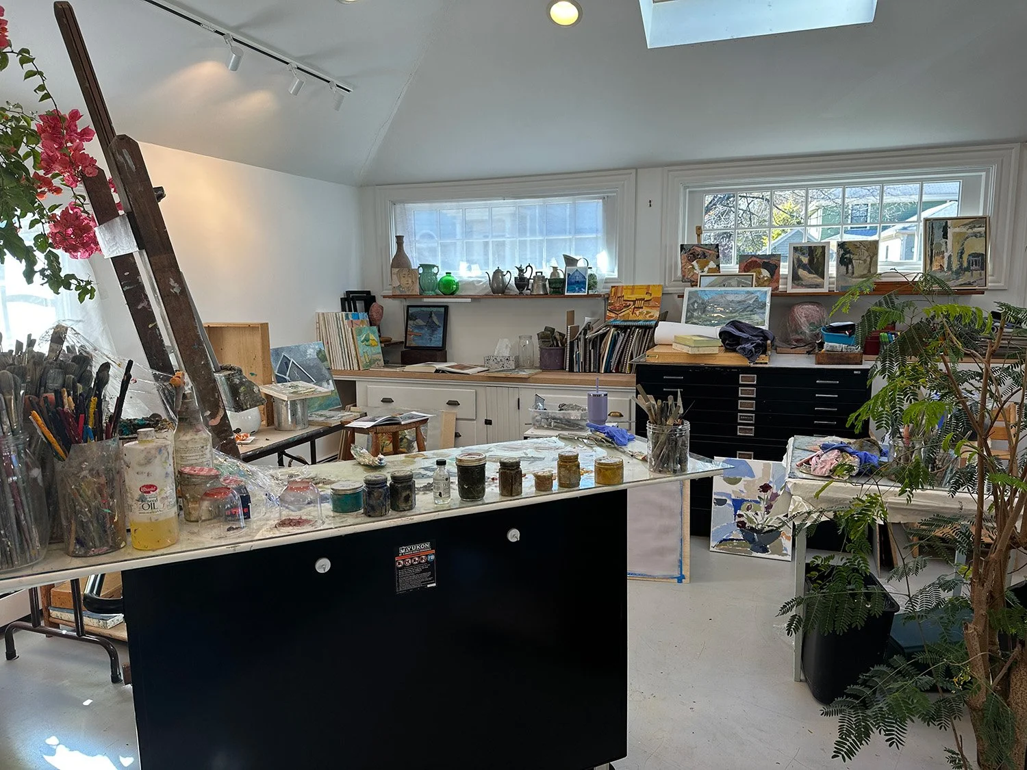 Interior of Wendy Cretella-Hodge's studio, a bright space filled with art supplies and paintings