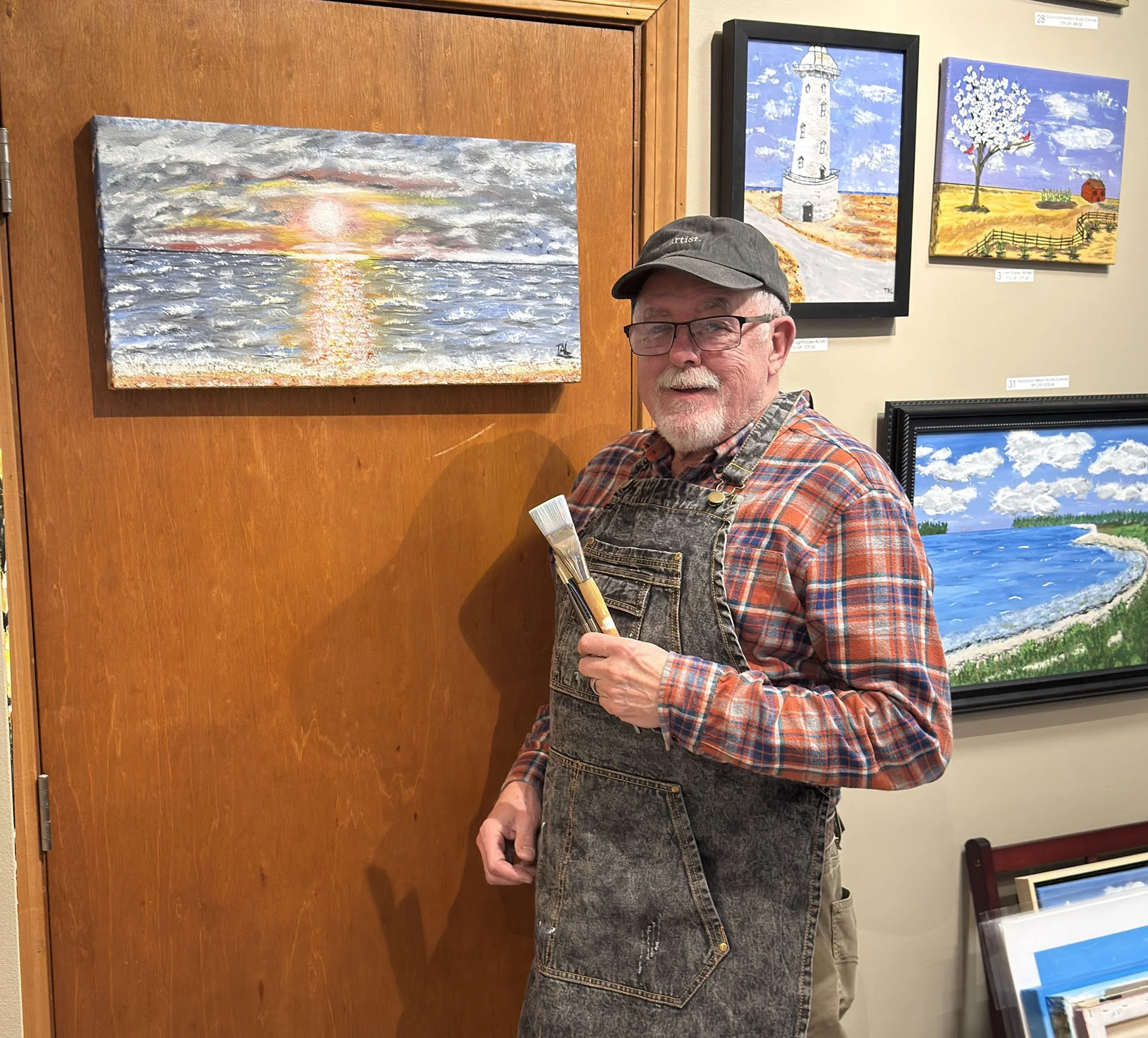 Thomas Leverett in his studio holding paint brushes