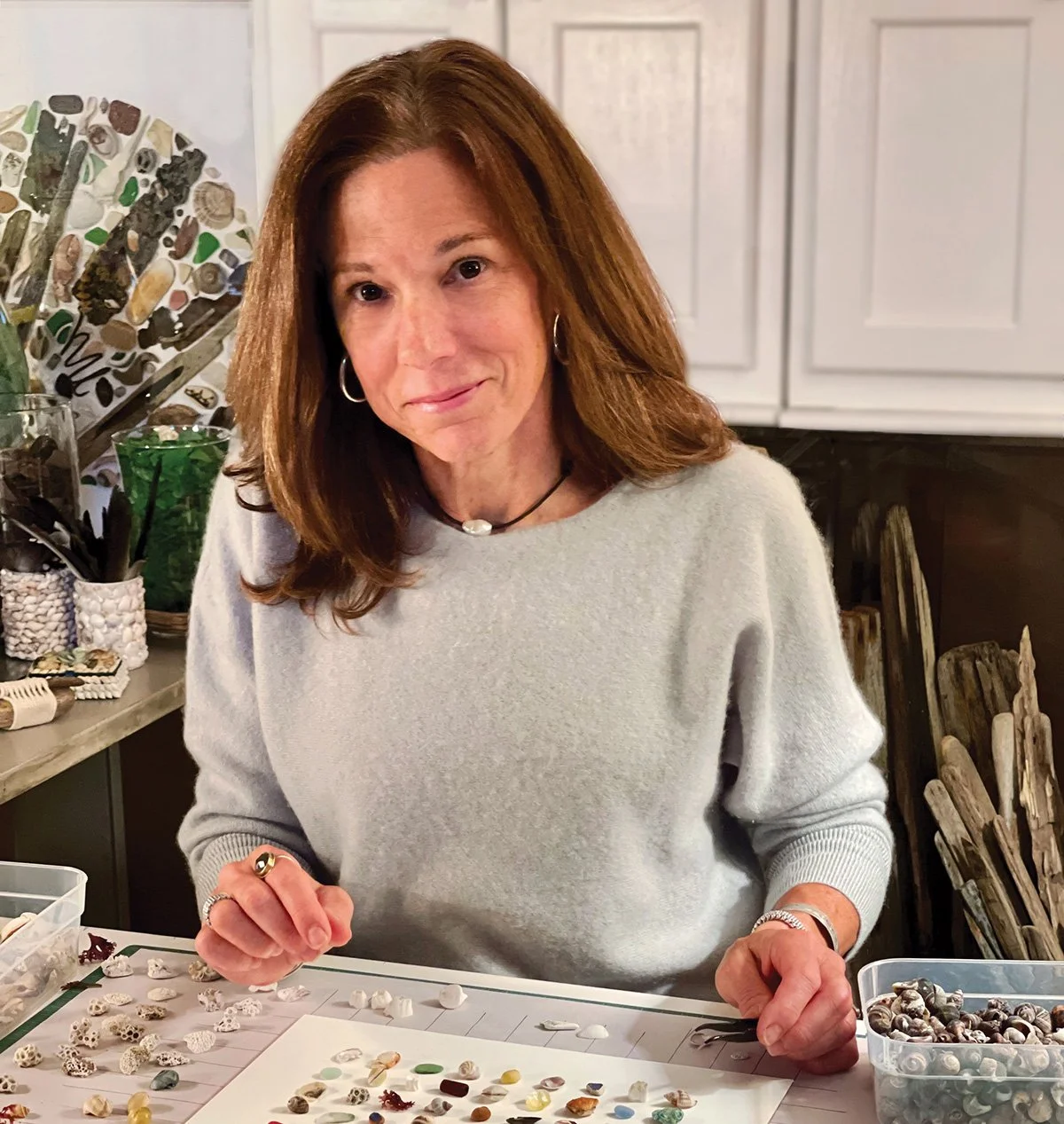 Nadine Flowers in her studio laying out shells and sea glass