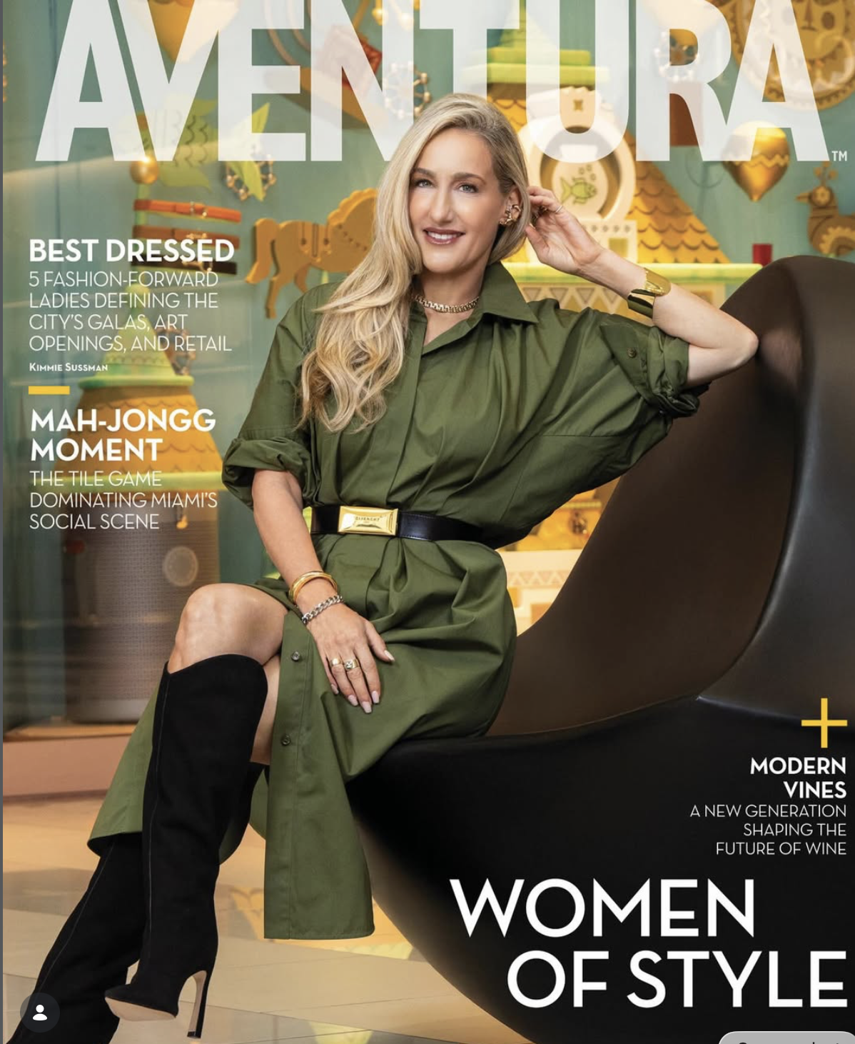 Magazines featuring a woman sitting on a modern black chair, wearing a green dress with a black belt and black high-heeled boots, smiling at the camera in a colorful, artistic background.