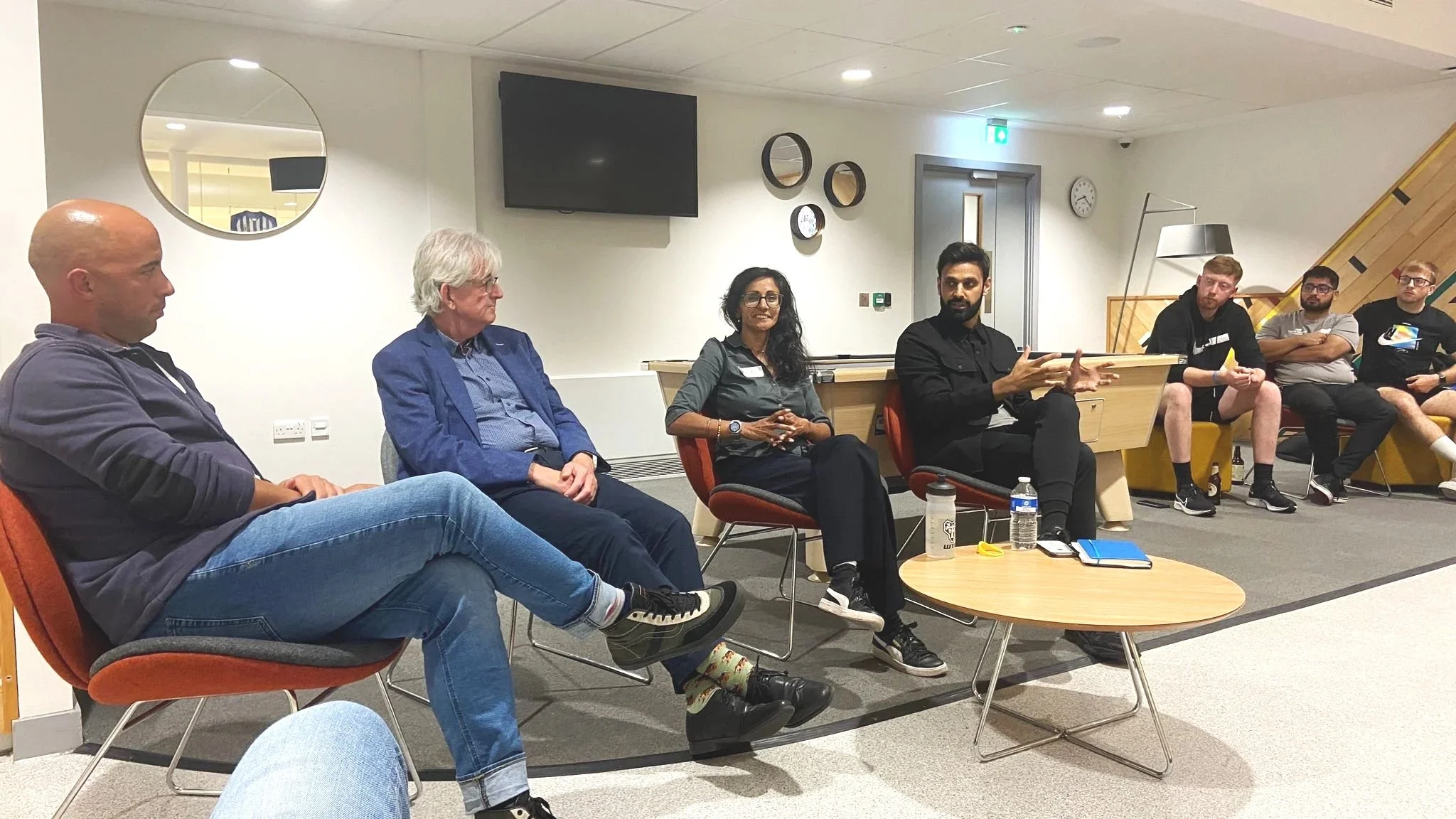 Dan moderating a panel with 3 other speakers who are all seated