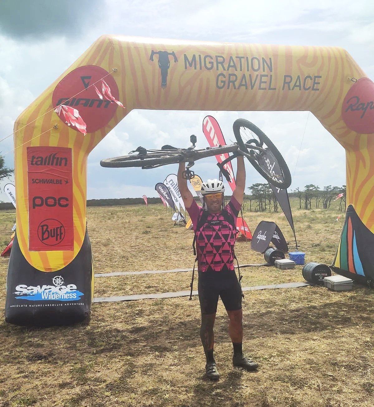 Dan completing an endurance bike race holding bike above his head