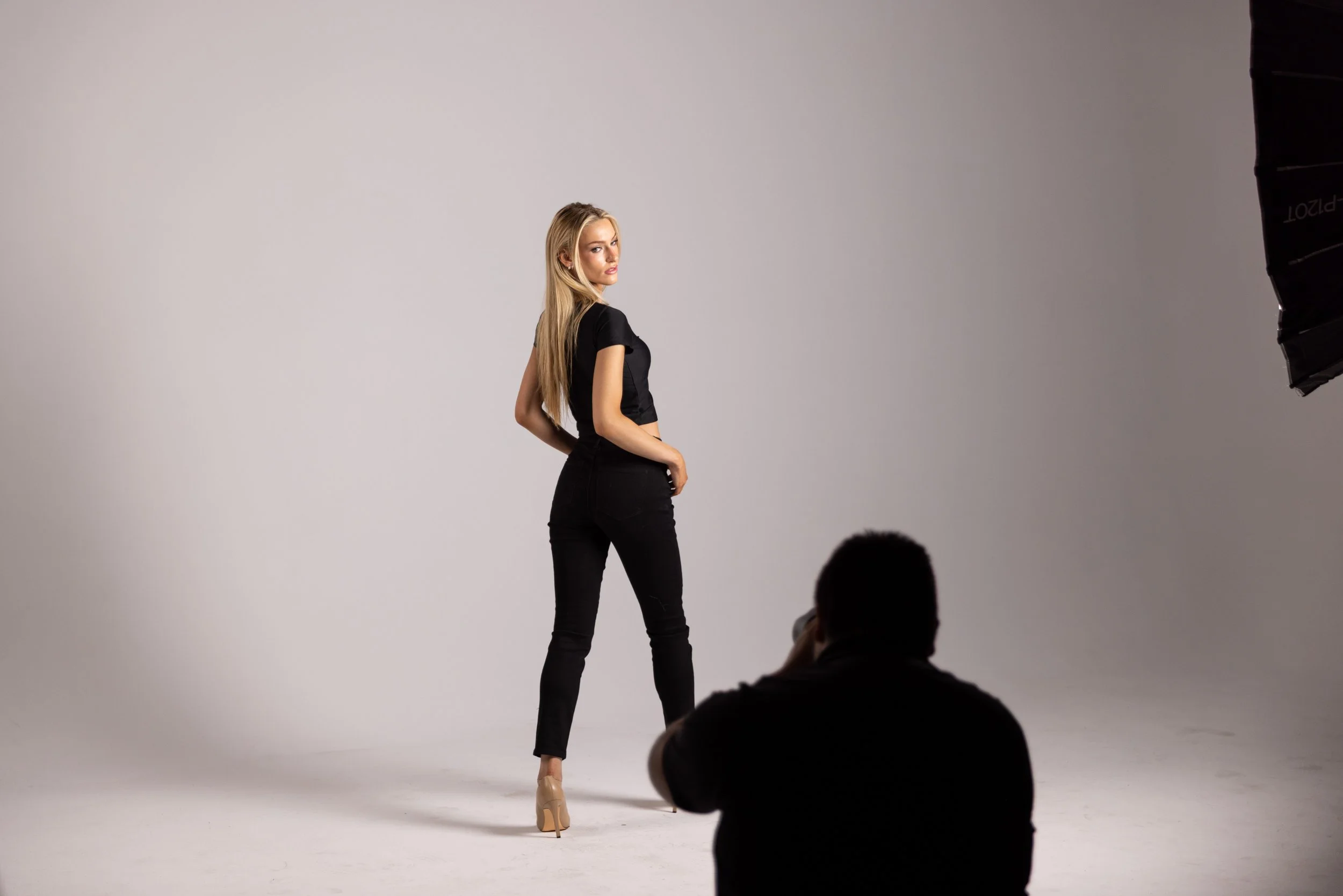 Photographer actively shooting a model during Cover Sessions at The Hive Studios in Phoenix, using professional studio lighting in an editorial photography workshop environment.