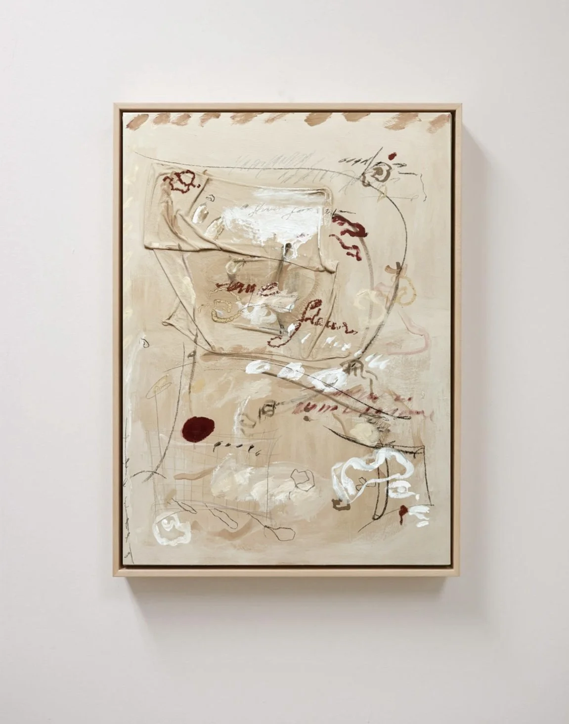 Abstract artwork with beige, white, and red brushstrokes and scribbles in a wooden frame on a white wall.
