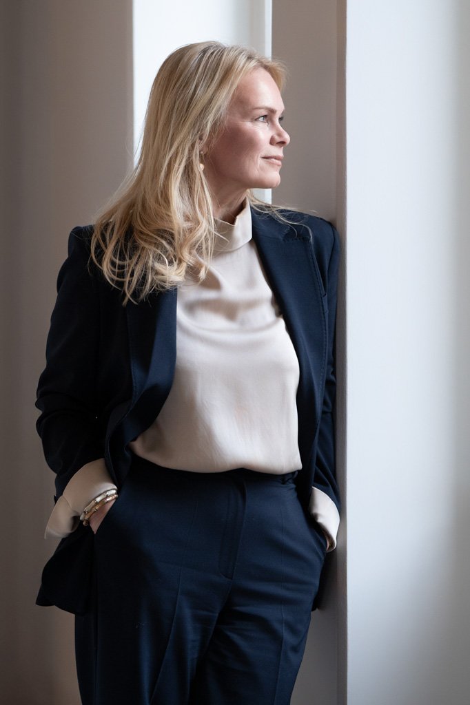 Tanja Törnkvist jakkupuvussa ikkunan äärellä, katse ulos