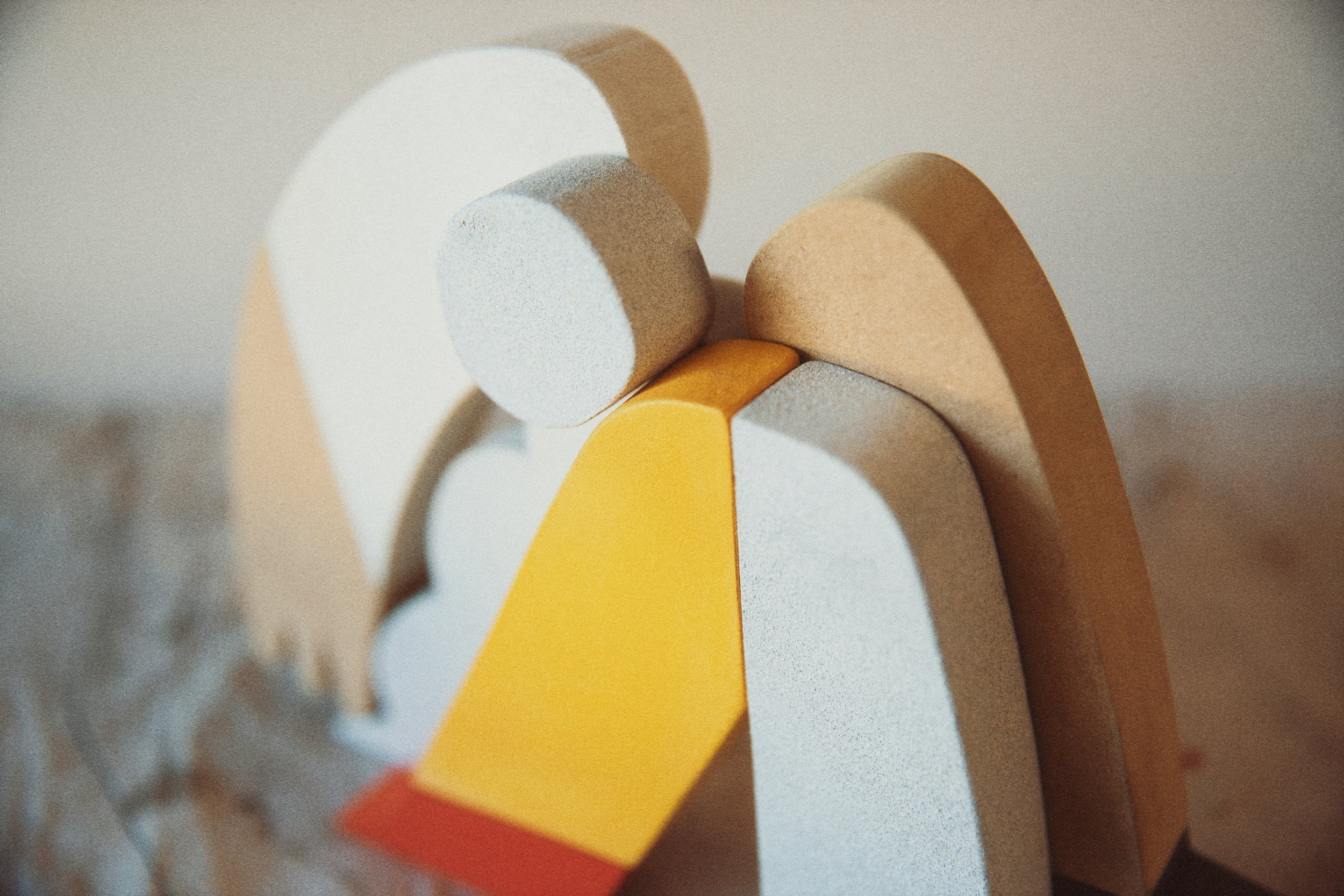 Close-up of colorful wooden letters spelling 'LOVE' arranged on a neutral surface.
