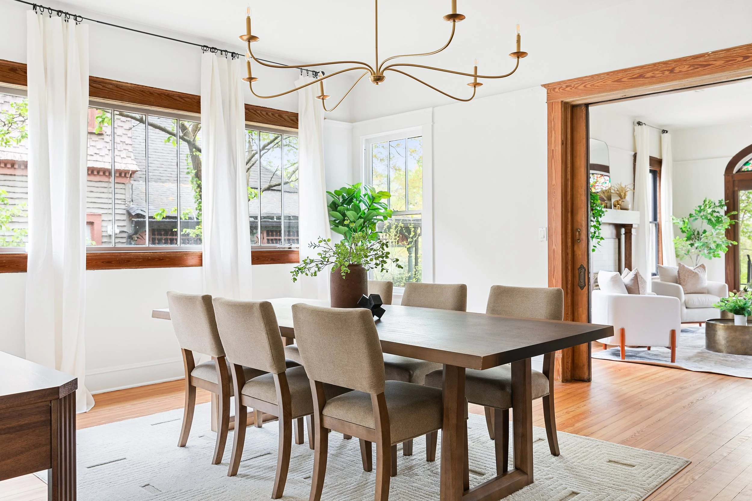 Traditional dining spaces featuring rich wood baseboards, classic wood tables, and chairs and a traditional console adds functionality. Ideal for those who appreciate enduring style and comfort.