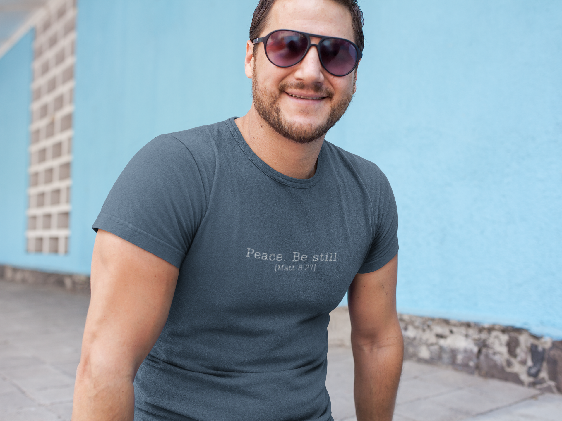 smiling-middle-aged-man-wearing-a-t-shirt-template-while-against-a-light-blue-wall-a16000.png