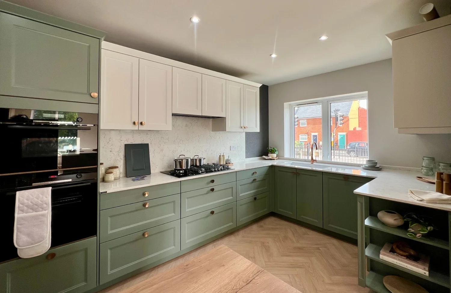 The British shaker display at our Aylesbury showroom: sage green doors, brass handles and white worktops