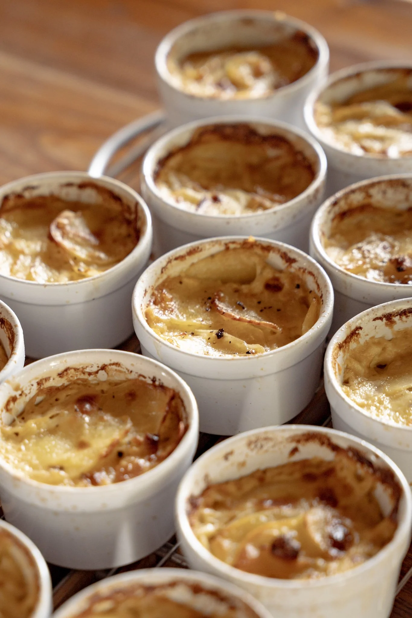 Plat de petits flans ou crèmes brûlées dans des ramequins en céramique blanche.