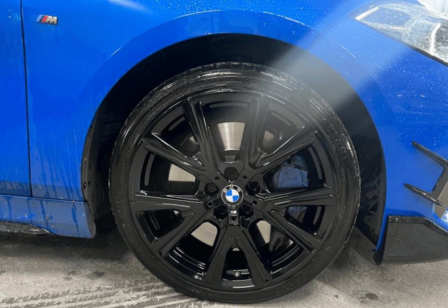 Blue BMW with alloy wheels painted gloss black in Liverpool