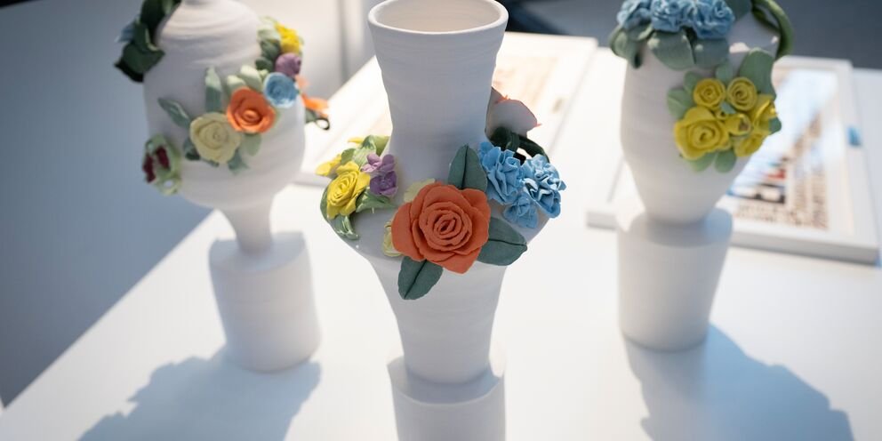 Image of three white ceramic trophies adorned with flowers. Work by Agata Nowak. Image: Greater London Authority/Caroline Teo
