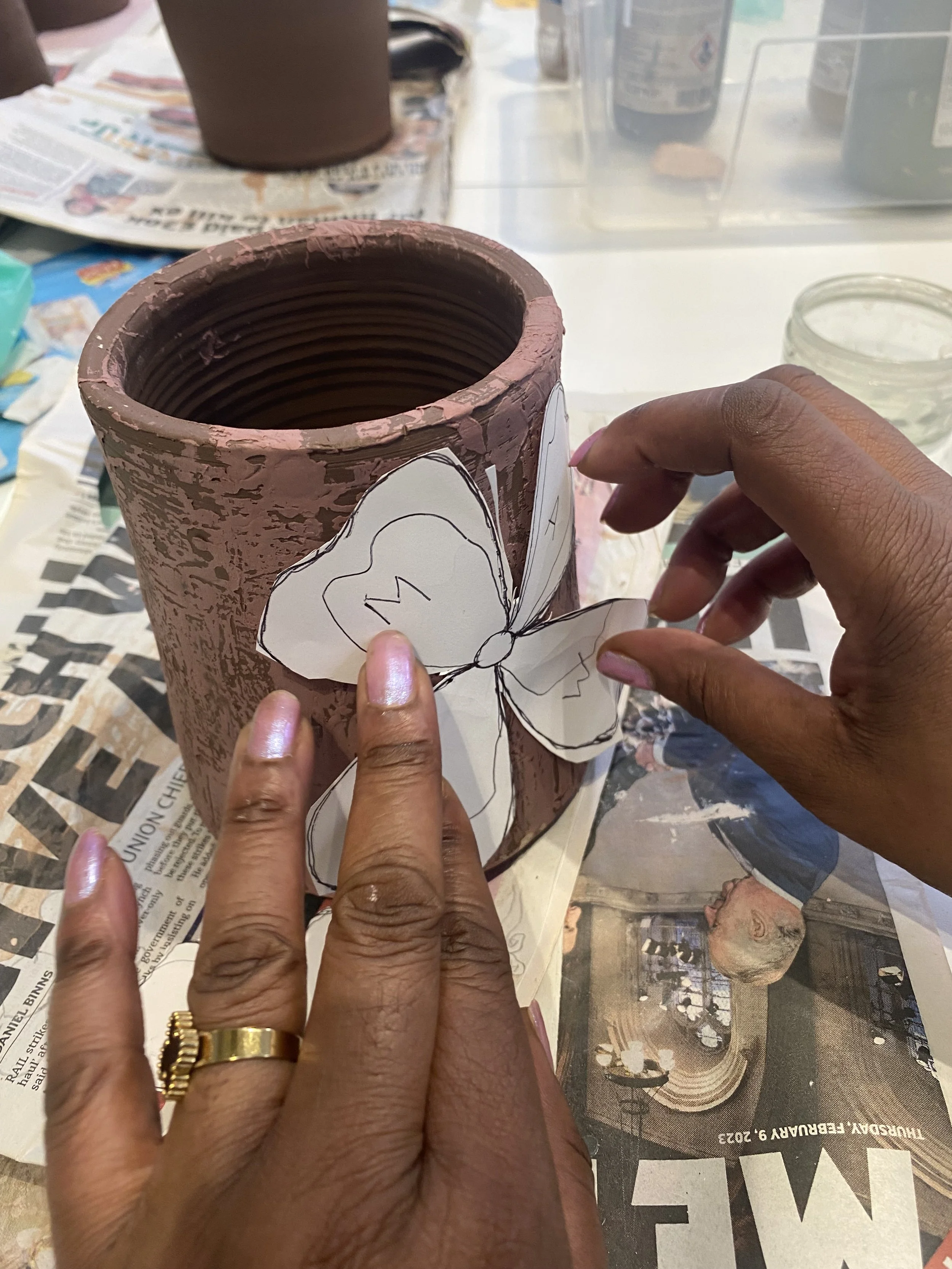 Woman's hands on a ceramic vessel