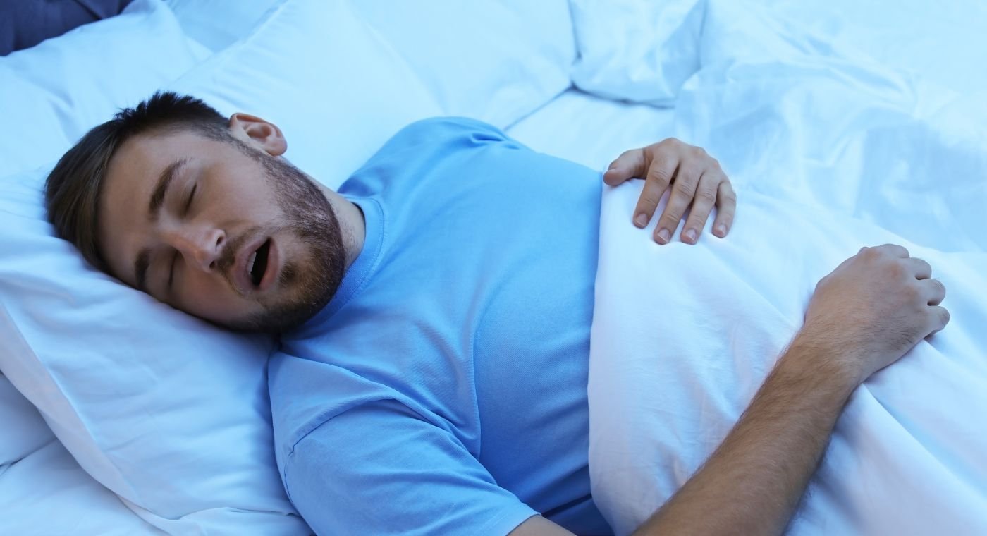 A snoring man suffering from obstructive sleep apnea sleeping with open mouth