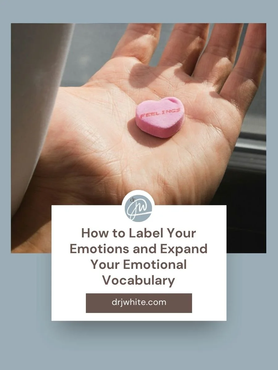 blog cover image of How to Label Your Emotions and Expand Your Emotional Vocabulary with hand in front of window holding a conversation heart candy with the word "feelings" written on it
