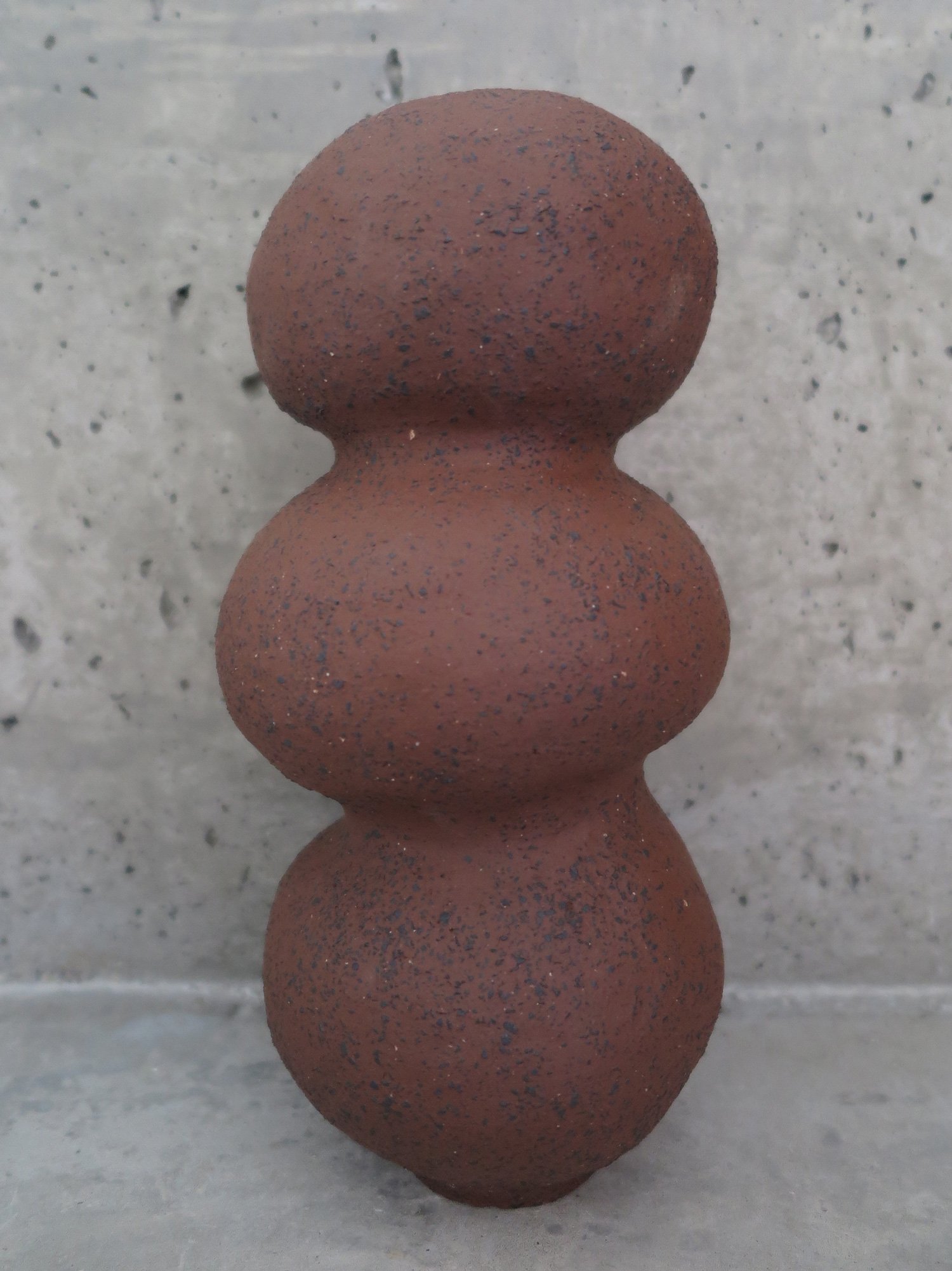 TALL VASE
unglazed raw clay with black grog. approximate measures 12cm diameter and 35cm tall.