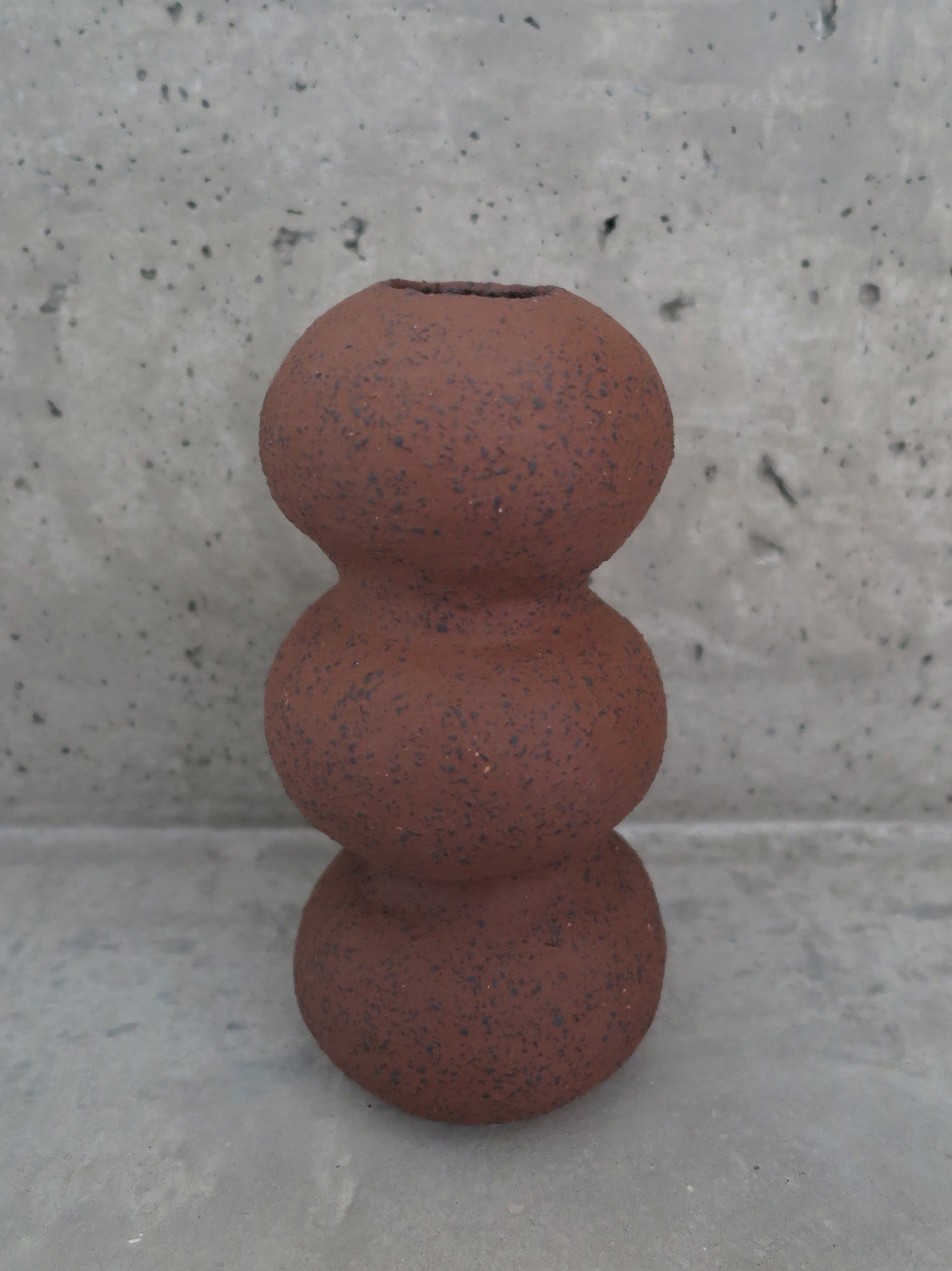 TALL VASE
unglazed raw clay with black grog. approximate measures 12cm diameter and 30cm tall.
