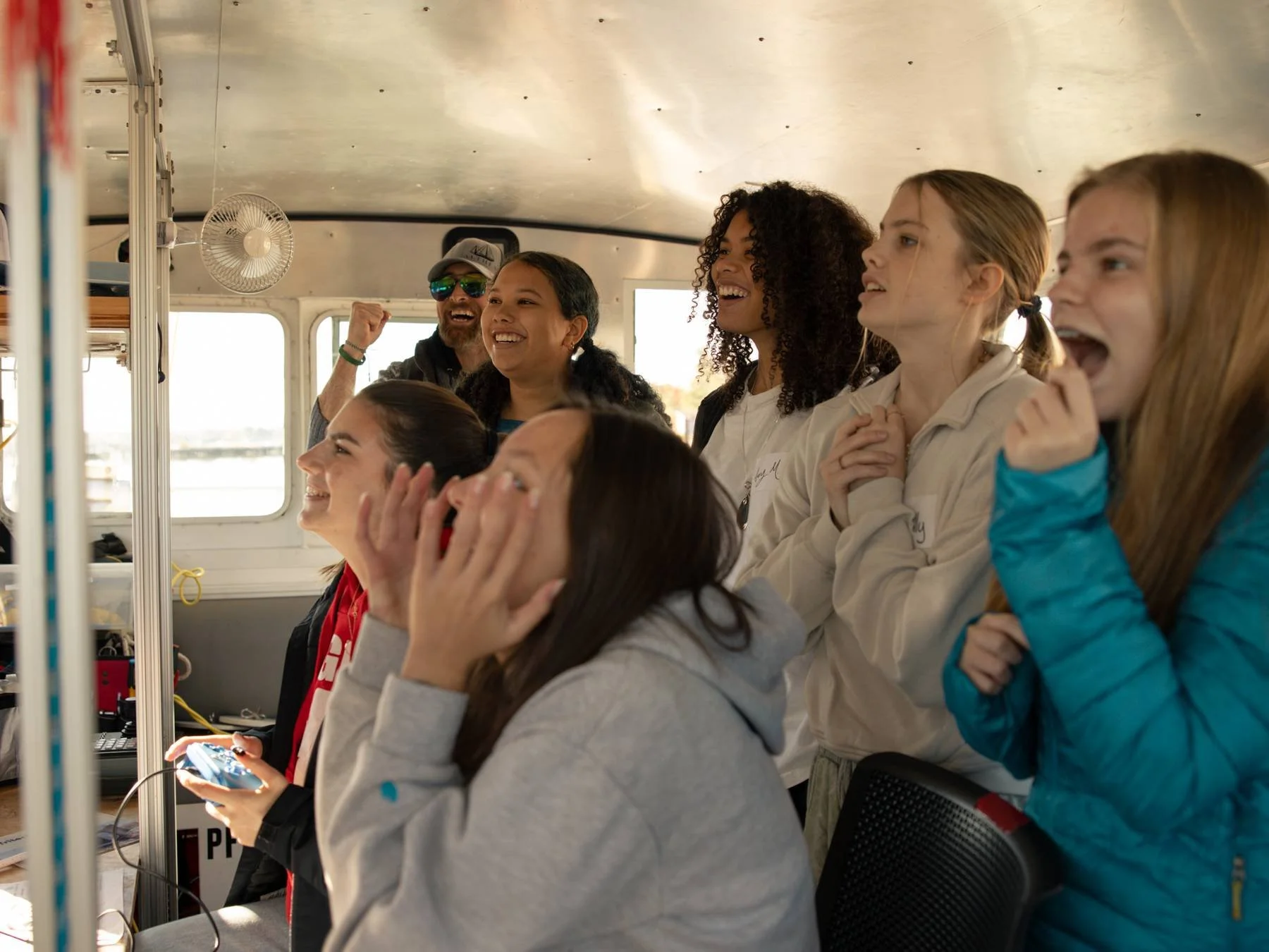 Group of students laughing and cheering as one student pilots the ROV