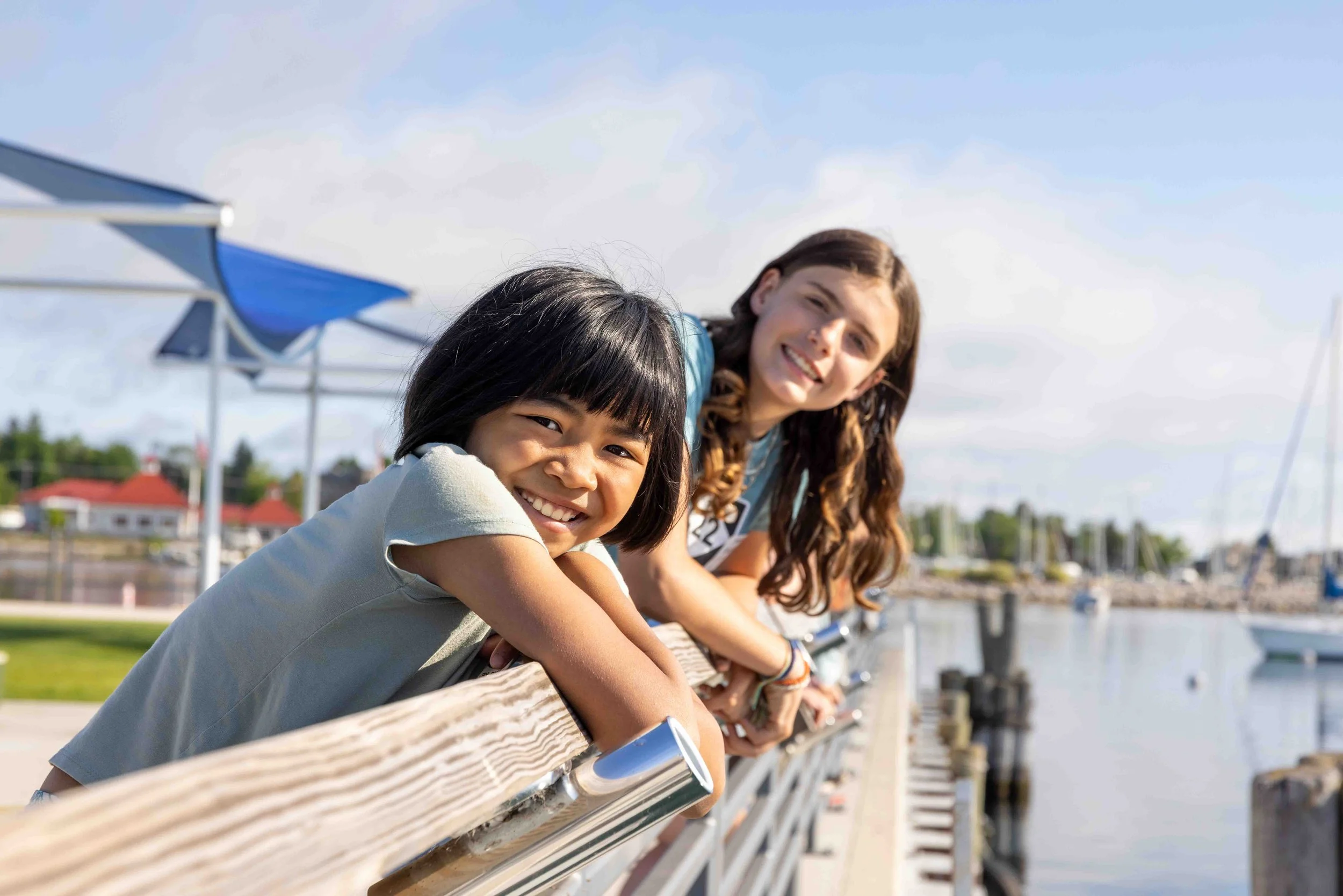 Children lean on pier railing