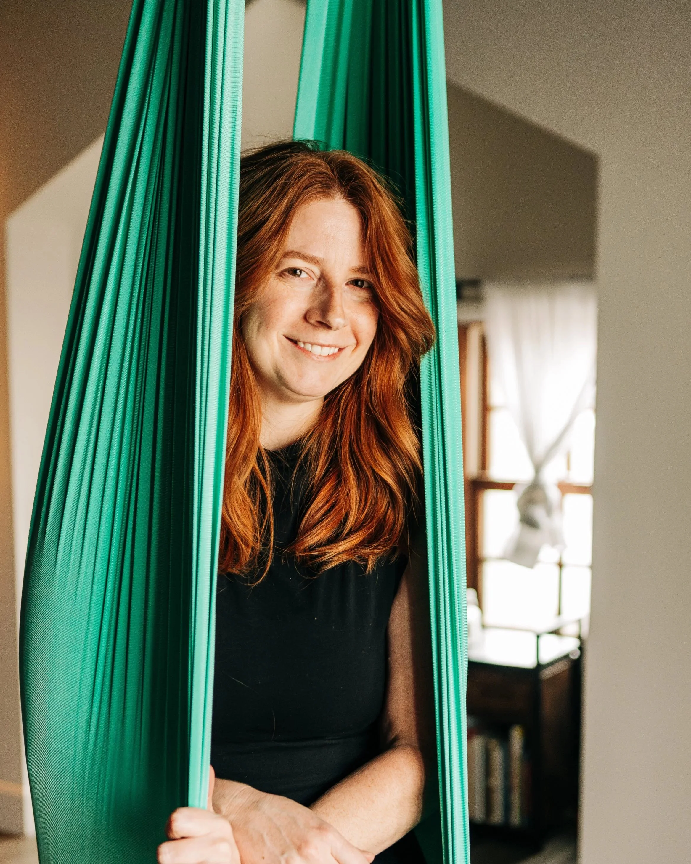 girl smiling in aerial yoga hammock